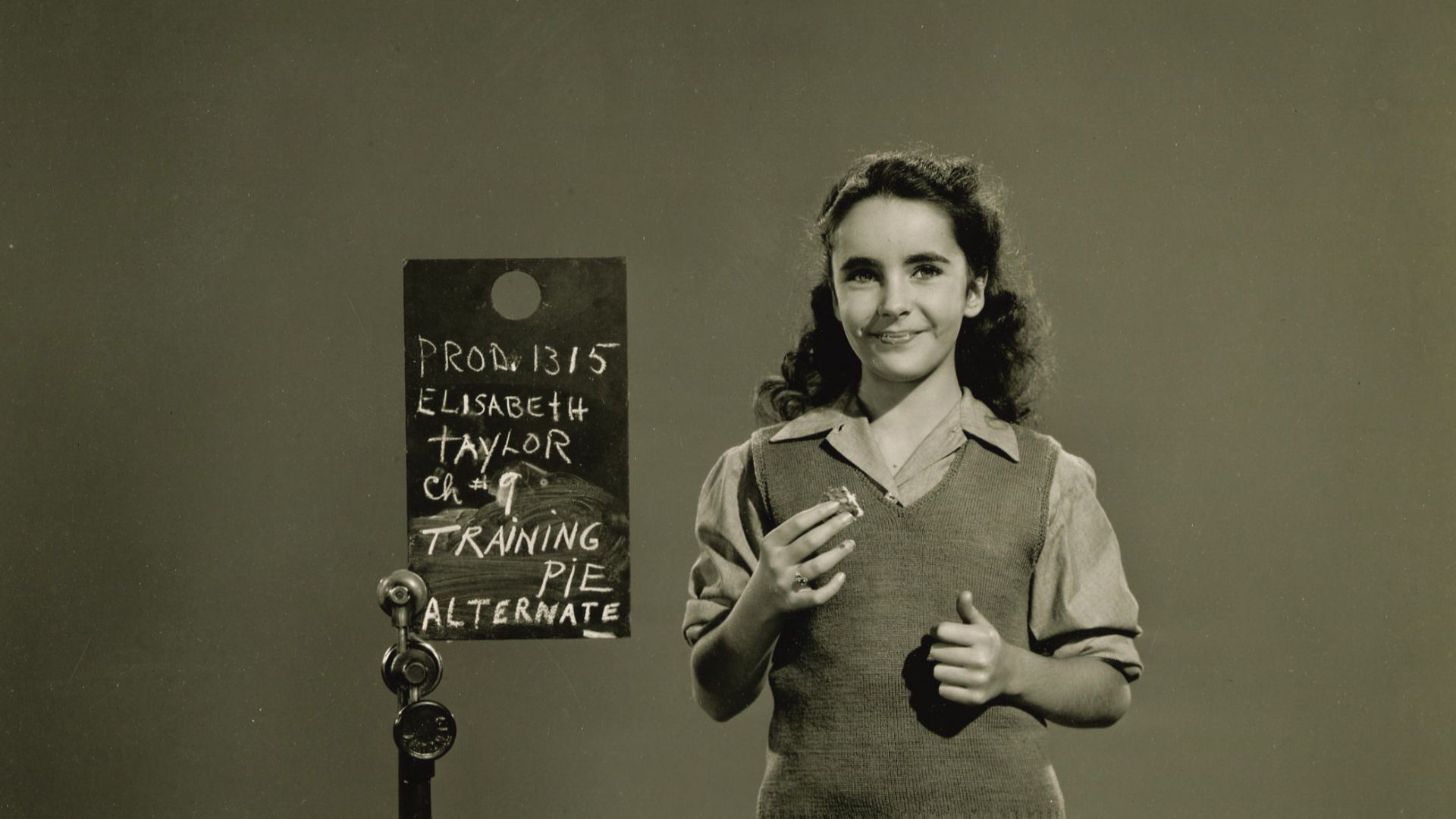 American actress Elizabeth Taylor, age 11, in a costume test photo dated November 8, 1943, in preparation for her role in the 1944 film National Velvet. Taylor appears to be eating an Oreo cookie.