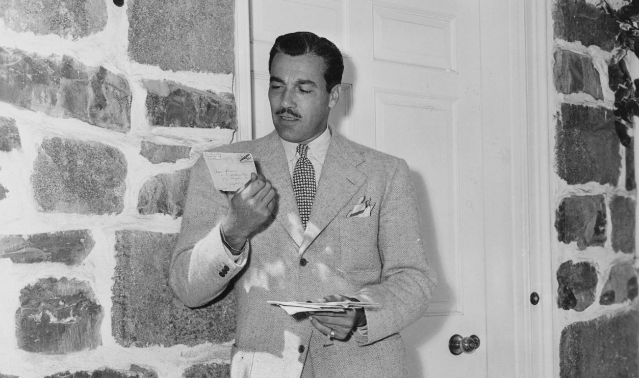 Actor Cesar Romero pictured reading his mail outside his house, after returning home following his time in Coast Guard Service, circa 1945. 