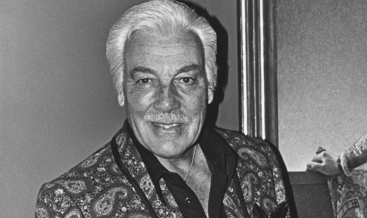 Hollywood film and TV actor Cesar Romero poses in the foyer of his home in Beverly Hills, California. Romero was perhaps best known for his role as 