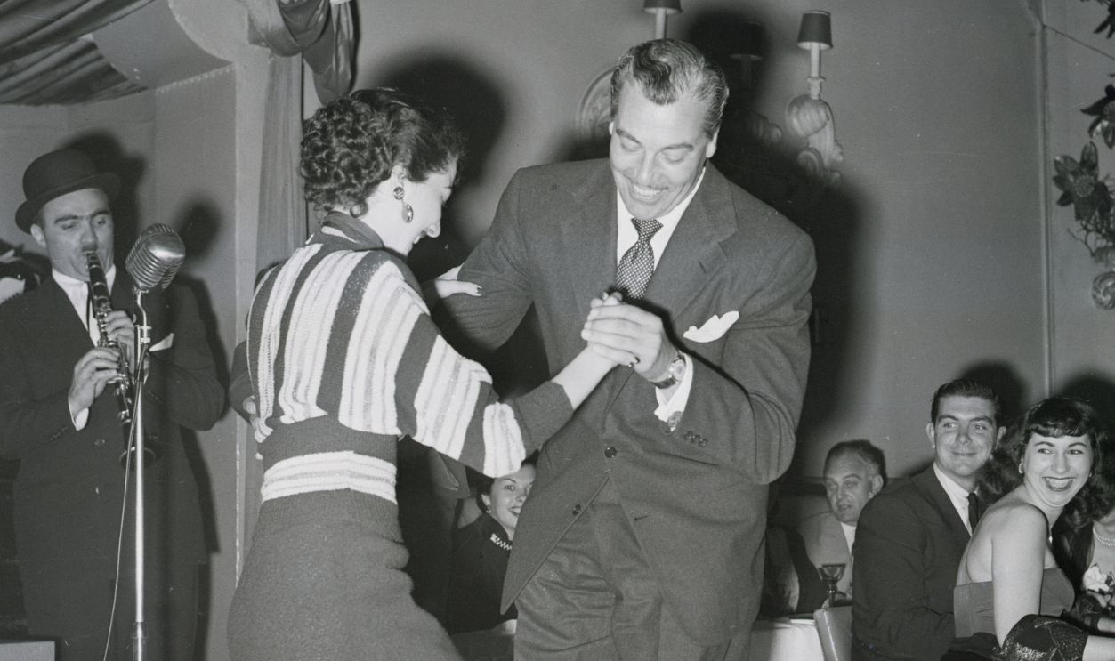 Movie star Cesar Romero and an unidentified partner strut their stuff on Le Coq Rouge's dance floor. They didn't win any prizes, but they had a lot of fun.