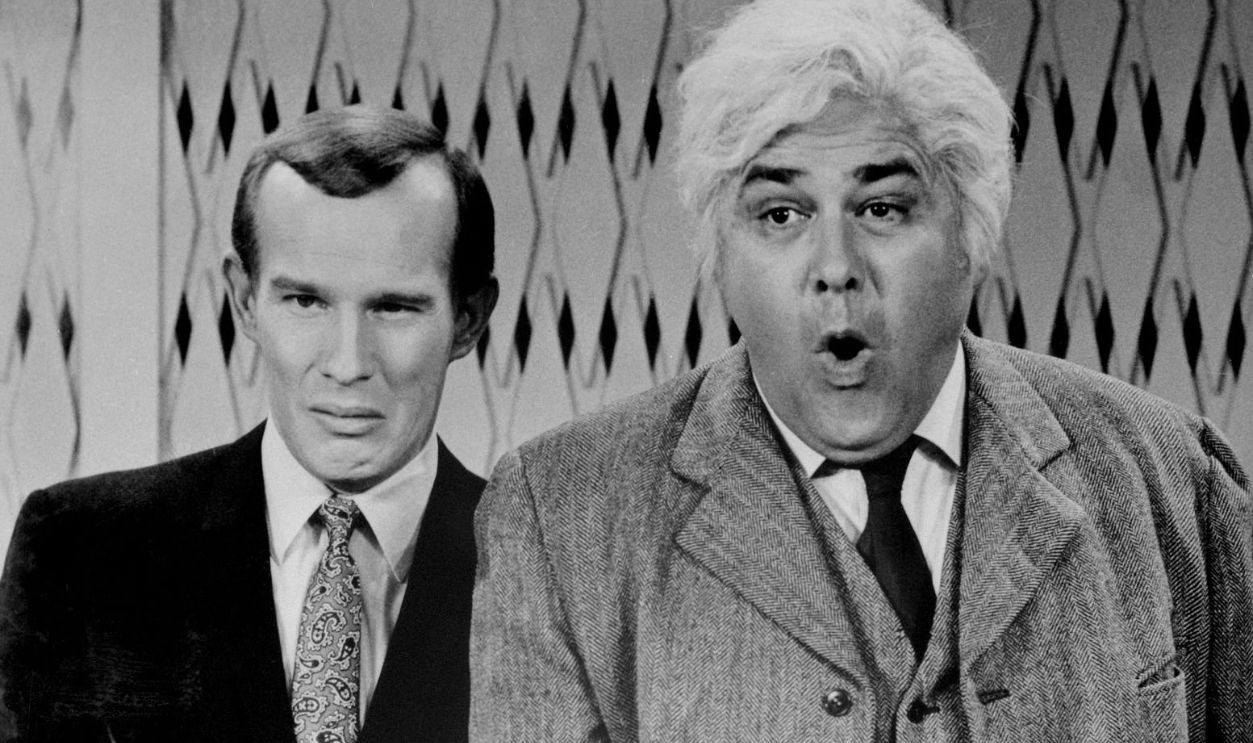 (Original Caption) Comedians Tom Smothers (left) and Jonathan Winters perform in a parody of a TV interview program in The Jonathan Winters Show program.