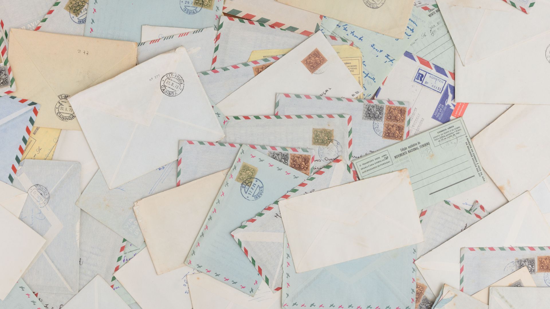 A collection of vintage airmail envelopes and postcards scattered with stamps.