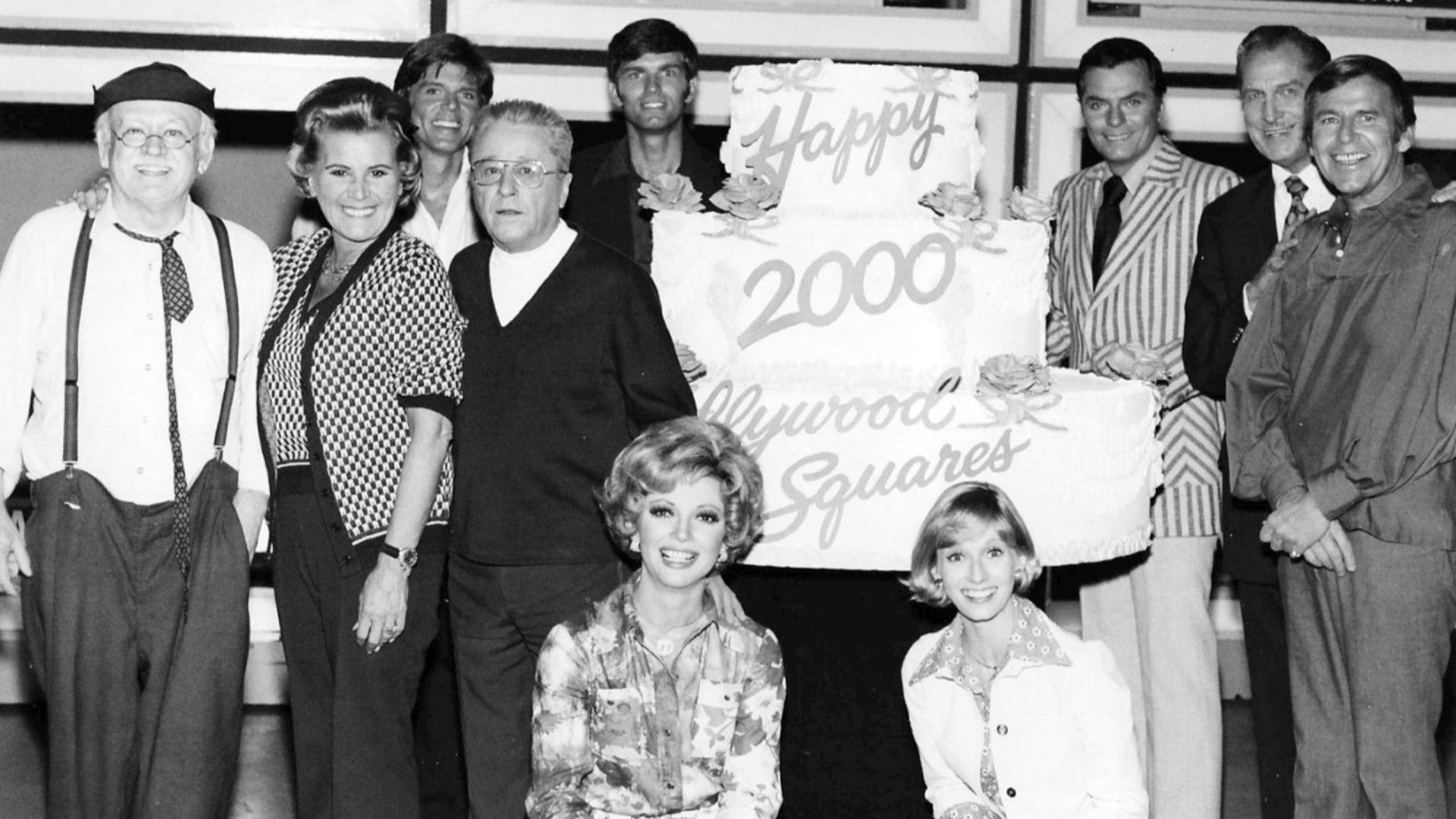 Photo from the television game show Hollywood Squares.  This was to celebrate the 2,000th show in 1974.  Pictured are Cliff Arquette as Charley Weaver, Rose Marie, John Davidson, George Gobel, Kent McCord, Peter Marshall, Vincent Price, Paul Lynde, Sandy 