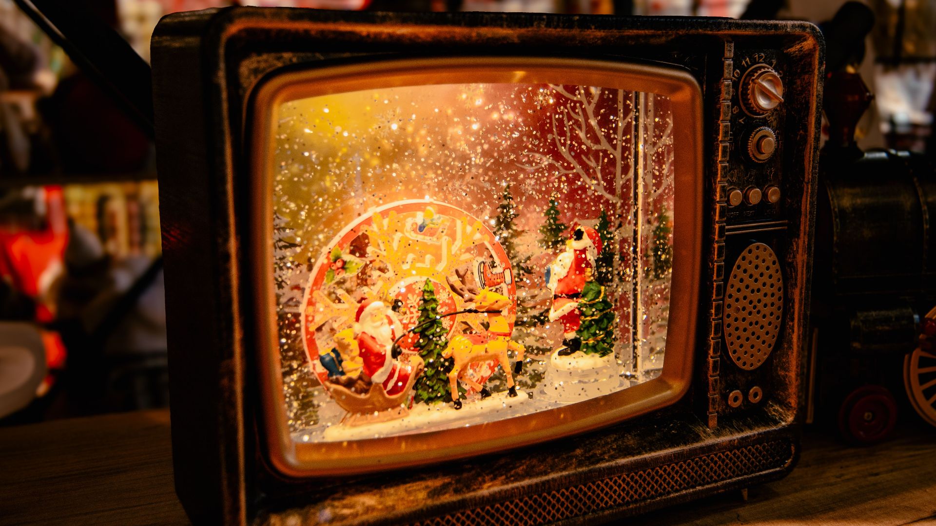 A festive vintage TV showcasing a captivating Christmas scene with snow, Santa, and trees.