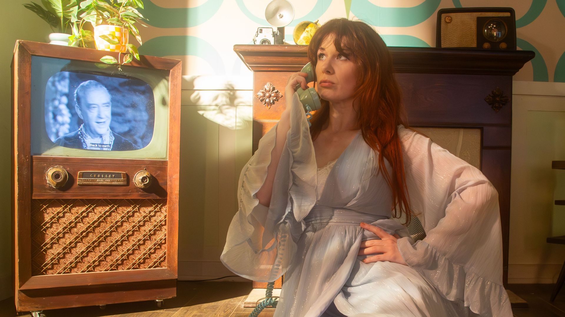 Retro living room scene with a woman in vintage attire, classic TV, and nostalgic decor.