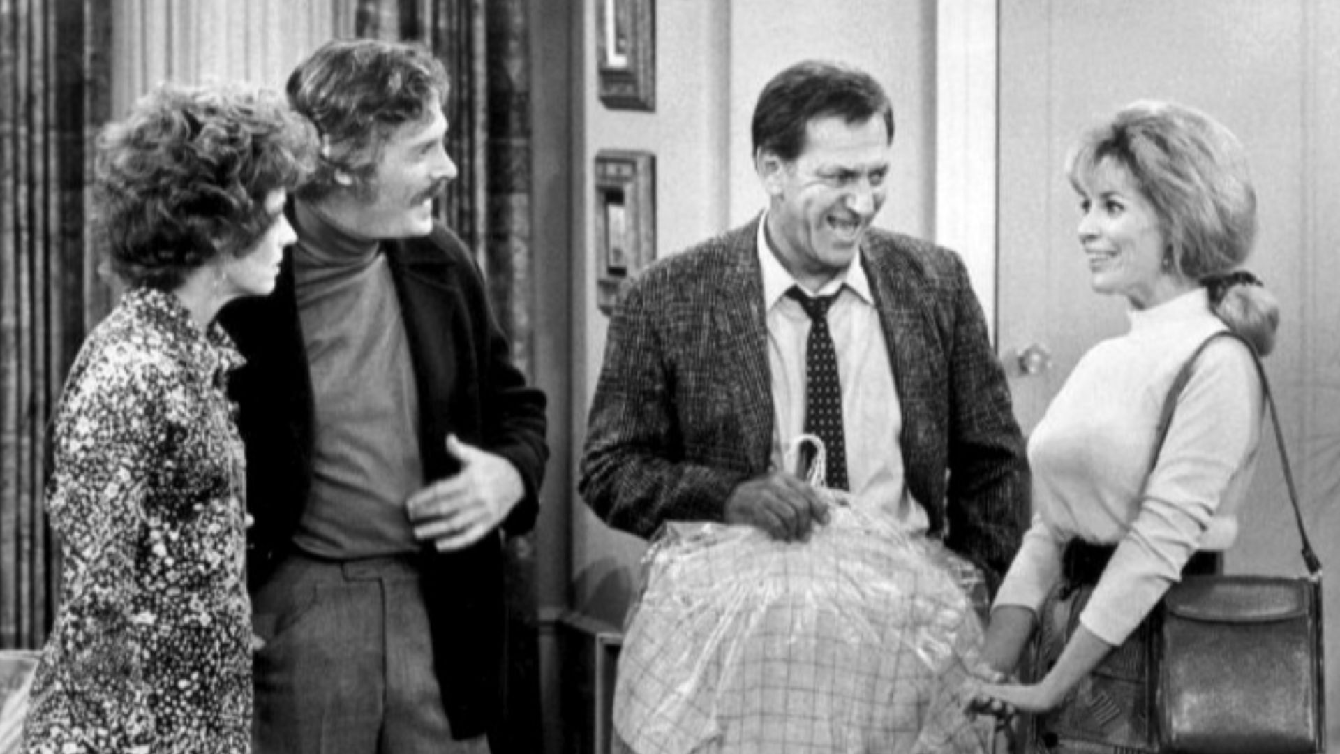 Photo from the television program The Odd Couple.  From left: Joan Hotchkis (Oscar's girlfriend, Nancy), Fred Beir (Nancy's brother, Ray), Jack Klugman (Oscar Madison), Janis Hansen (Felix's ex-wife, Gloria). Trouble brews when Oscar introduces Gloria to 