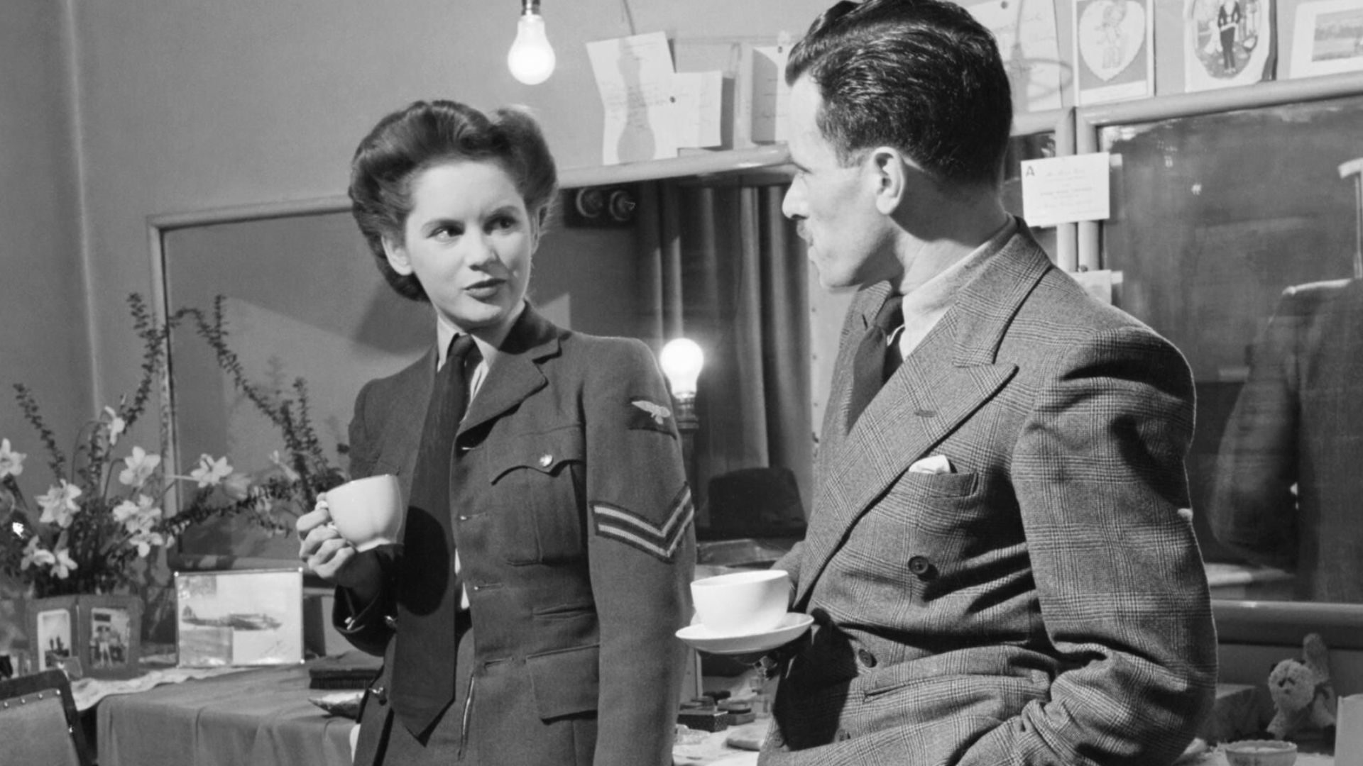 Actress Muriel Pavlow chats with casting director Bob Lennard of the Associated British Picture Corporation in her dressing room at the Globe Theatre, London during 1945.
Actress Muriel Pavlow drinks tea in her dressing room at the Globe Theatre, London, 