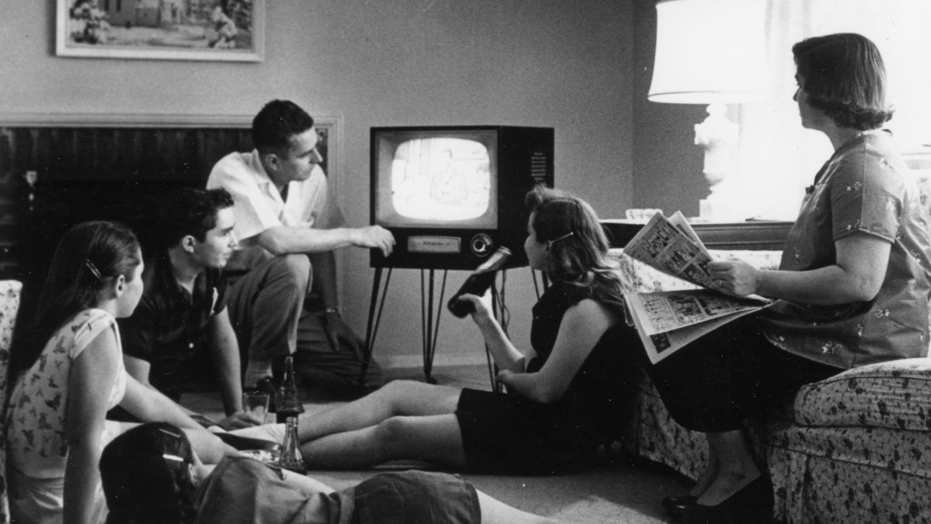 Family watching television in their home, c. 1958