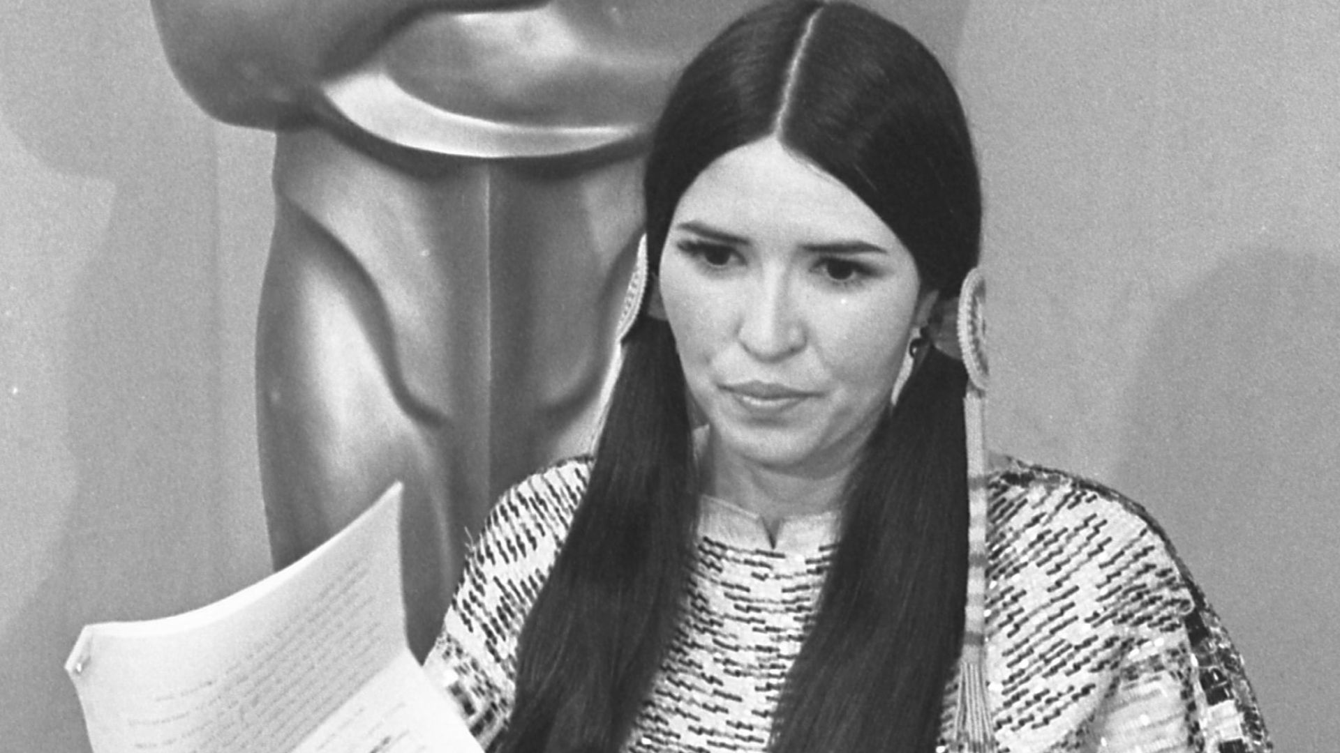 Sacheen Littlefeather standing before the Oscar statue holding Marlon Brando's statement at the 45th annual Academy Awards in Los Angeles.