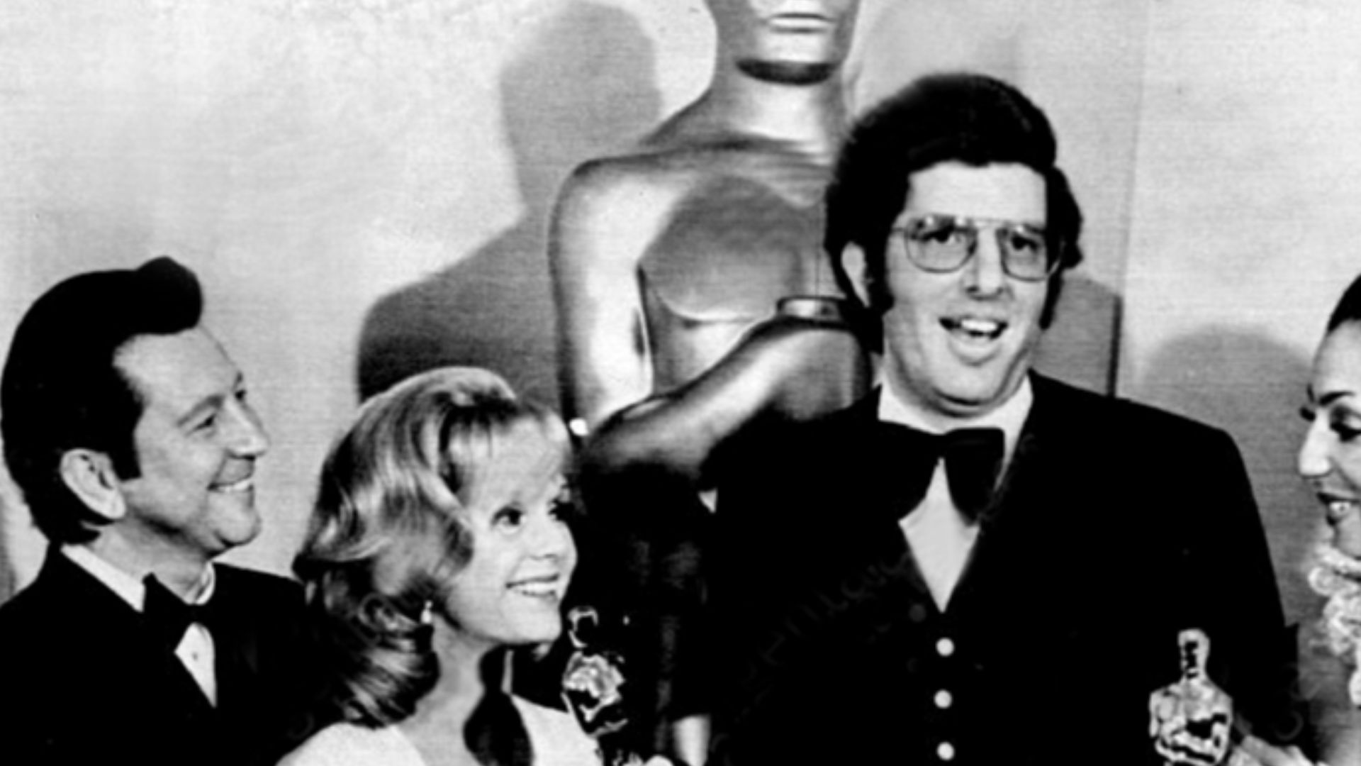 Press photo of Marvin Hamlisch receiving three Academy Awards. With him are Donald O'Connor, Debbie Reynolds and Cher Bono.