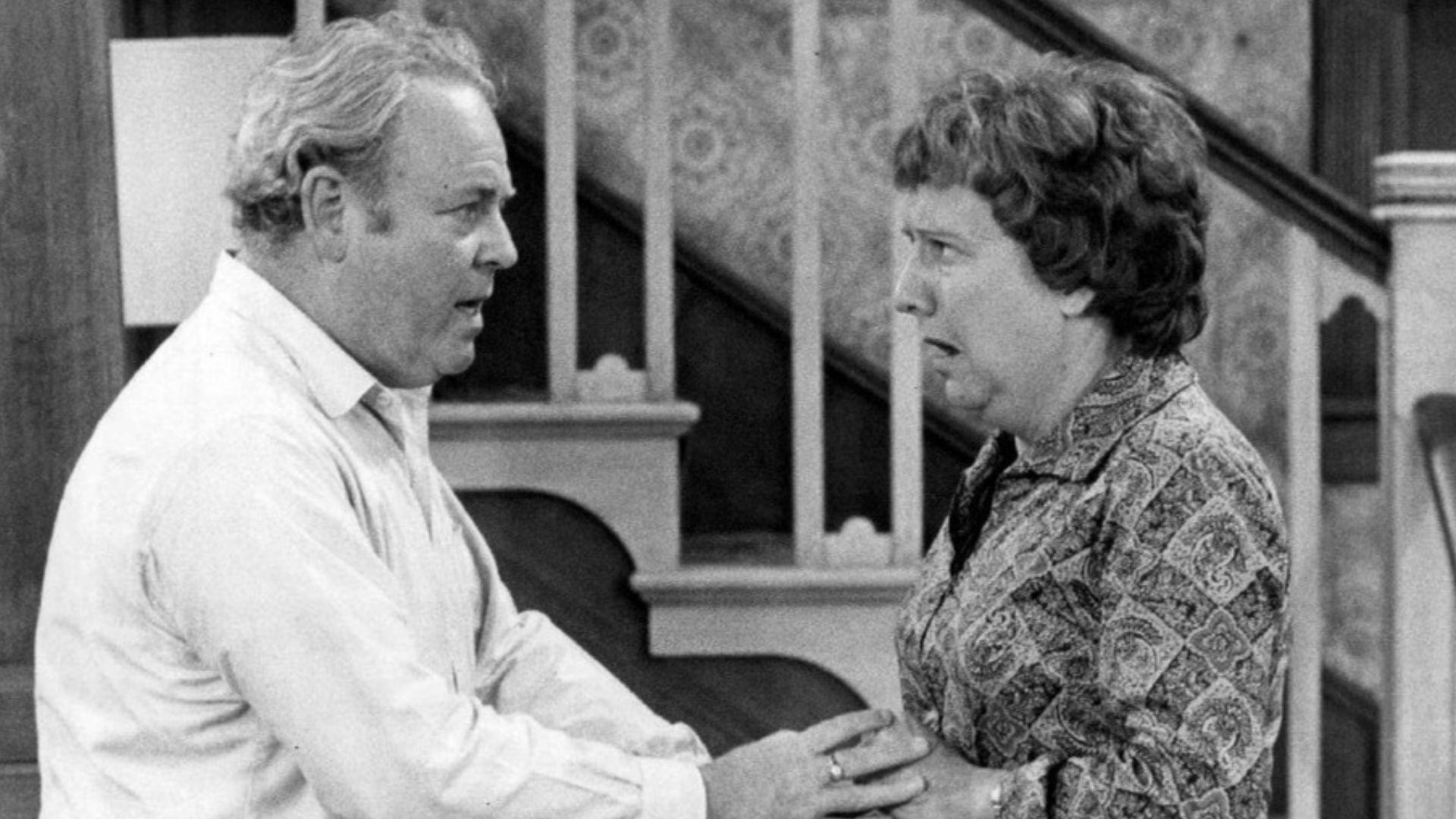 Photo of Carroll O'Connor and Jean Stapleton as Archie and Edith Bunker from the television program All In the Family.  When Archie comes home in a great mood with gifts for everyone in the family, happiness turns to shock and anger when it's discovered h
