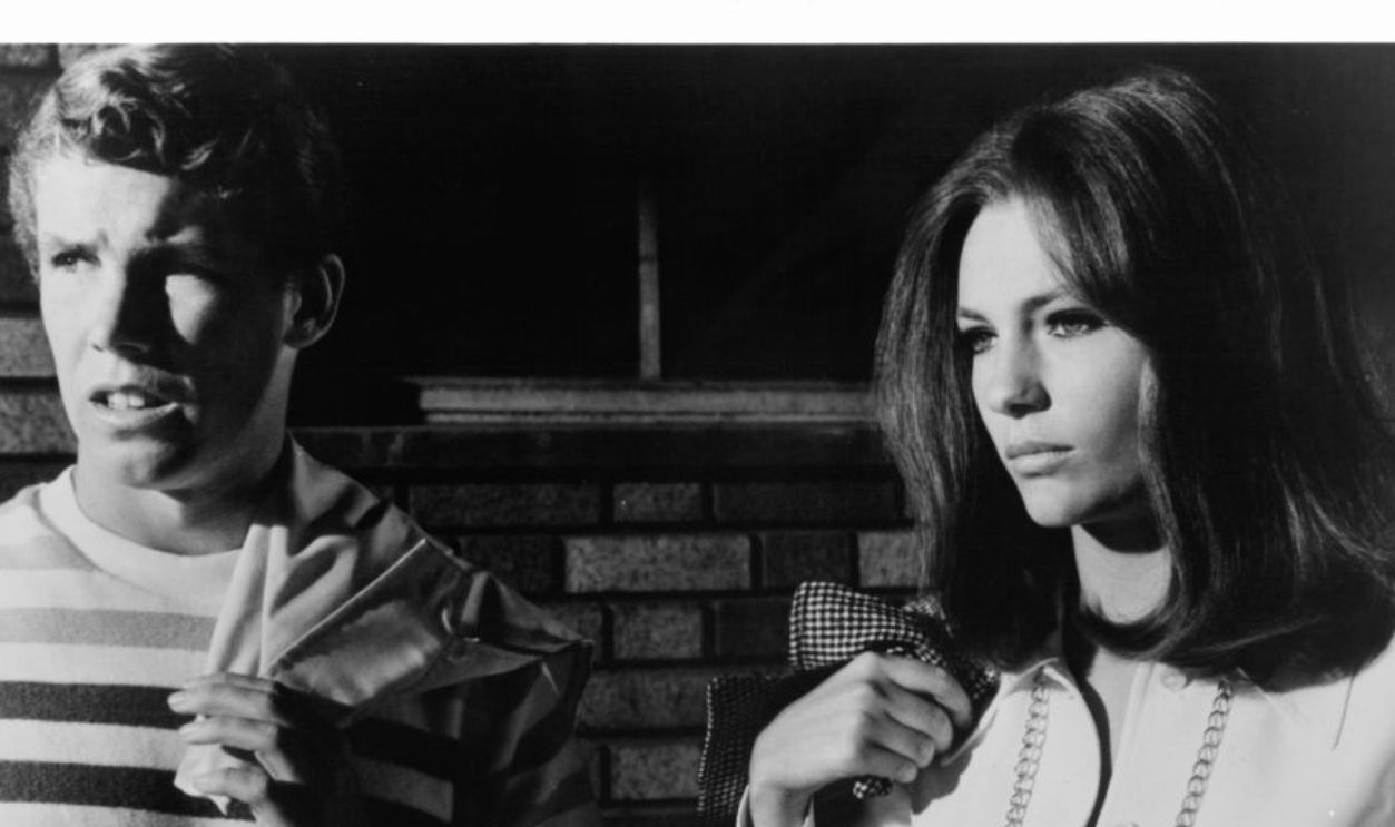 Ricky Kelman and Jacqueline Bisset looking out together in a scene from the film 'The First Time', 1969. 