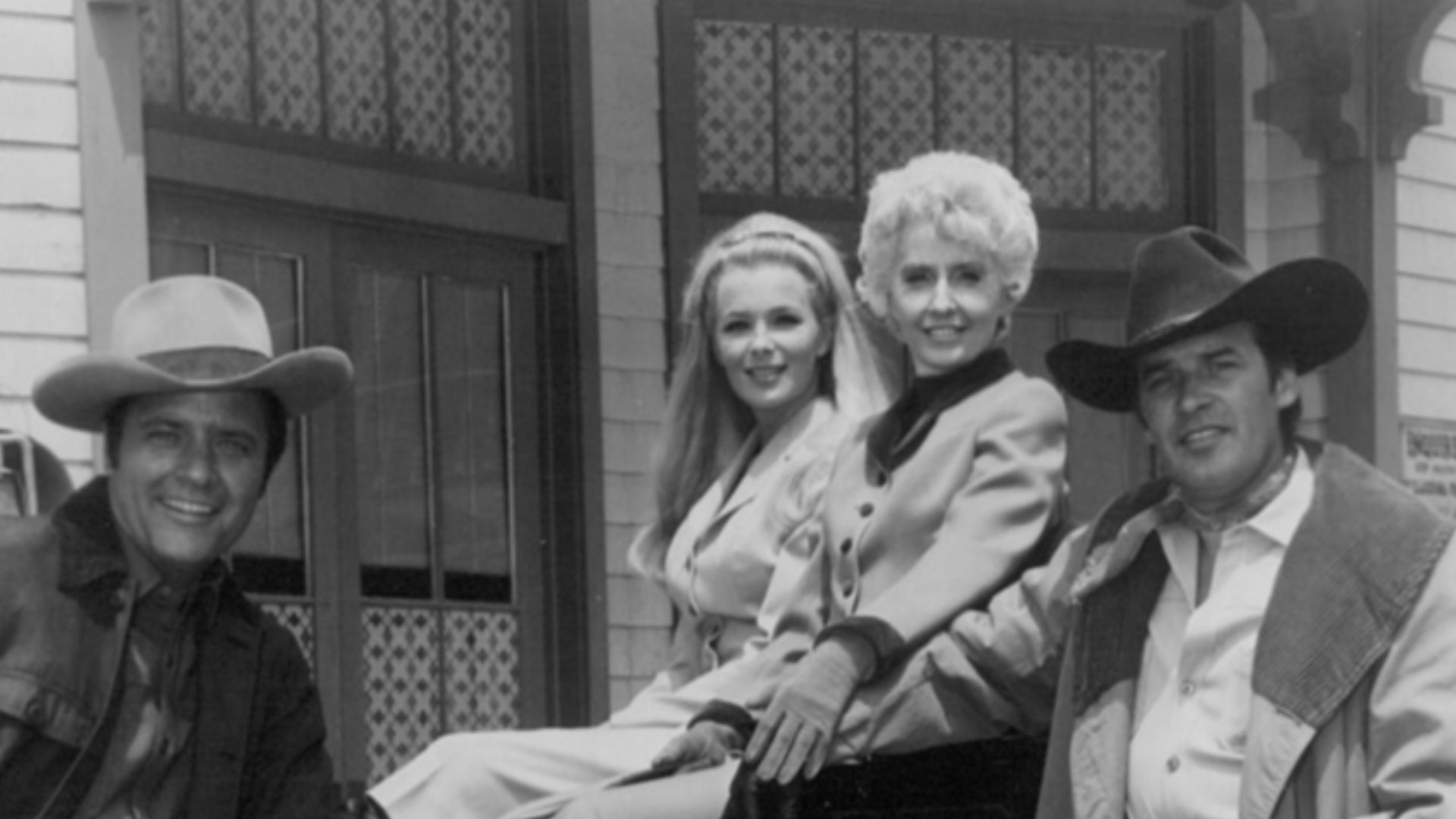 Cast photo from the television Western The Big Valley. From left: Richard Long, Linda Evans, Barbara Stanwyck, Peter Breck, and Lee Majors by wagon wheel.