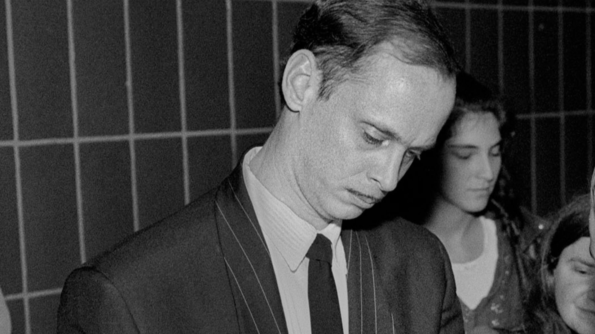 John Waters signing the jean jacket sleeve of a fan at the Massachusetts College of Art in Boston, 1990.