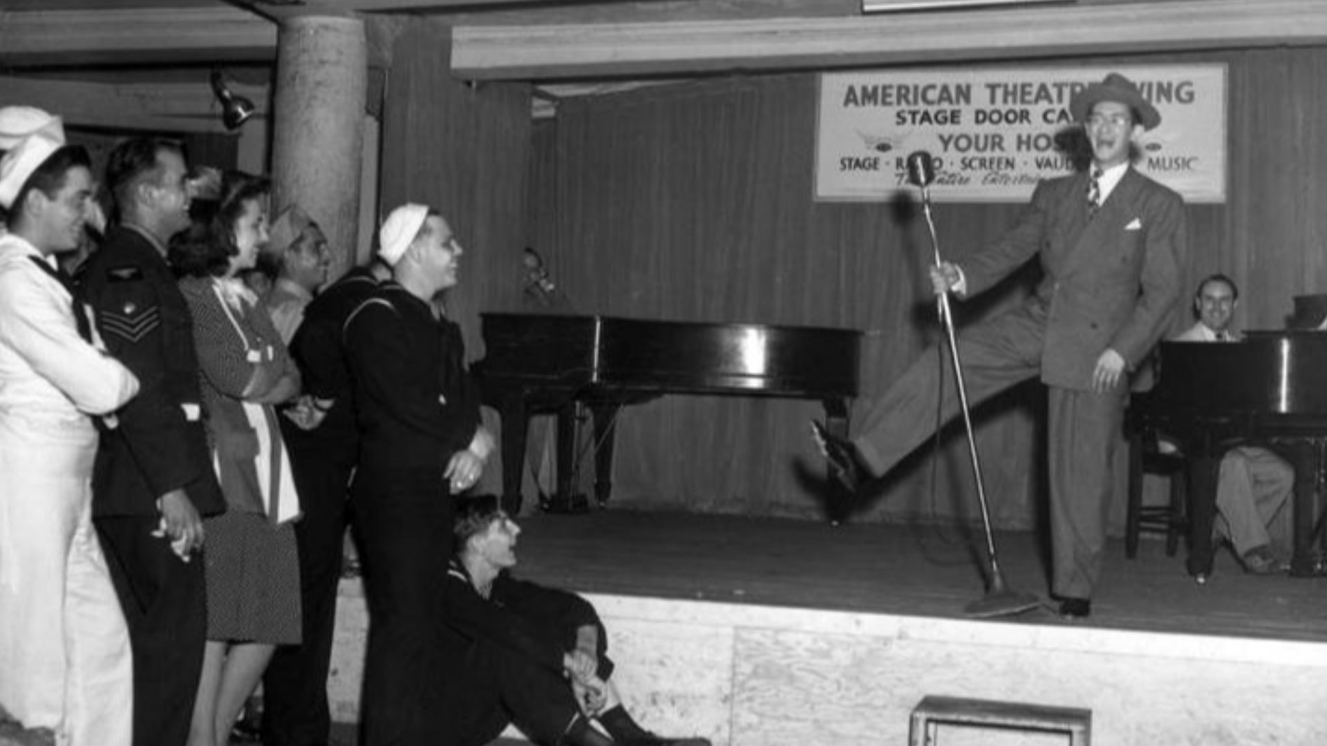 Comedian on stage, entertaining service members at the Stage Door Canteen in New York CityBroadway entertainment for the armed forces of all nations at the Stage Door canteen, run by the American Theater wing. Actors wait on soldiers and sailors who eat a
