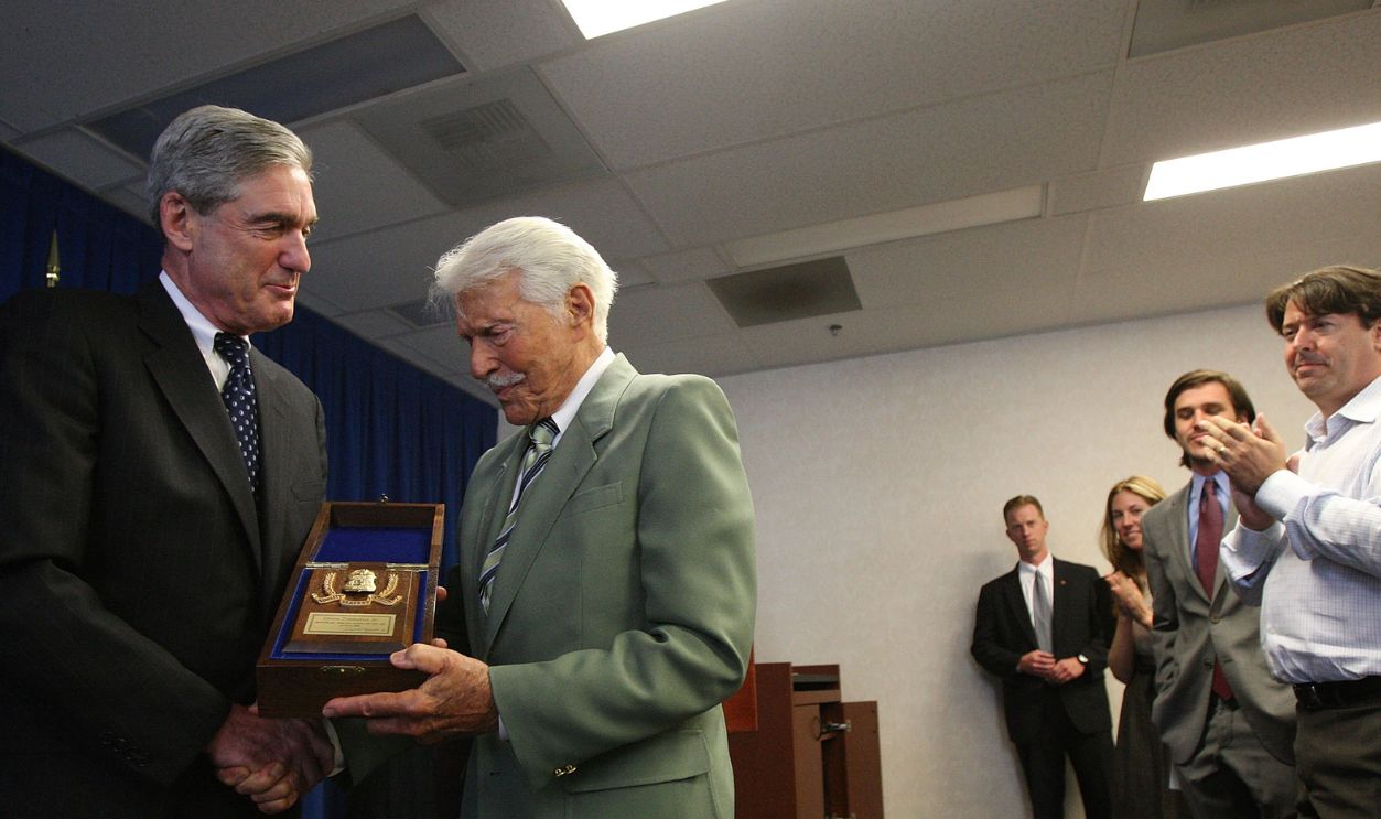 LOS ANGELES, CA - JUNE 08: Family members applaud as FBI director Robert Mueller (L) presents actor Efrem Zimbalist Jr. with a badge as an honorary special agent, the highest civilian honor awarded by the FBI, on June 8, 2009 in Los Angeles, California. The 90-year-old actor starred as Inspector Lewis Erskine in the TV show The FBI from 1965 to 1974, a roll that made Zimbalist an icon who inspired a generation of FBI agents.