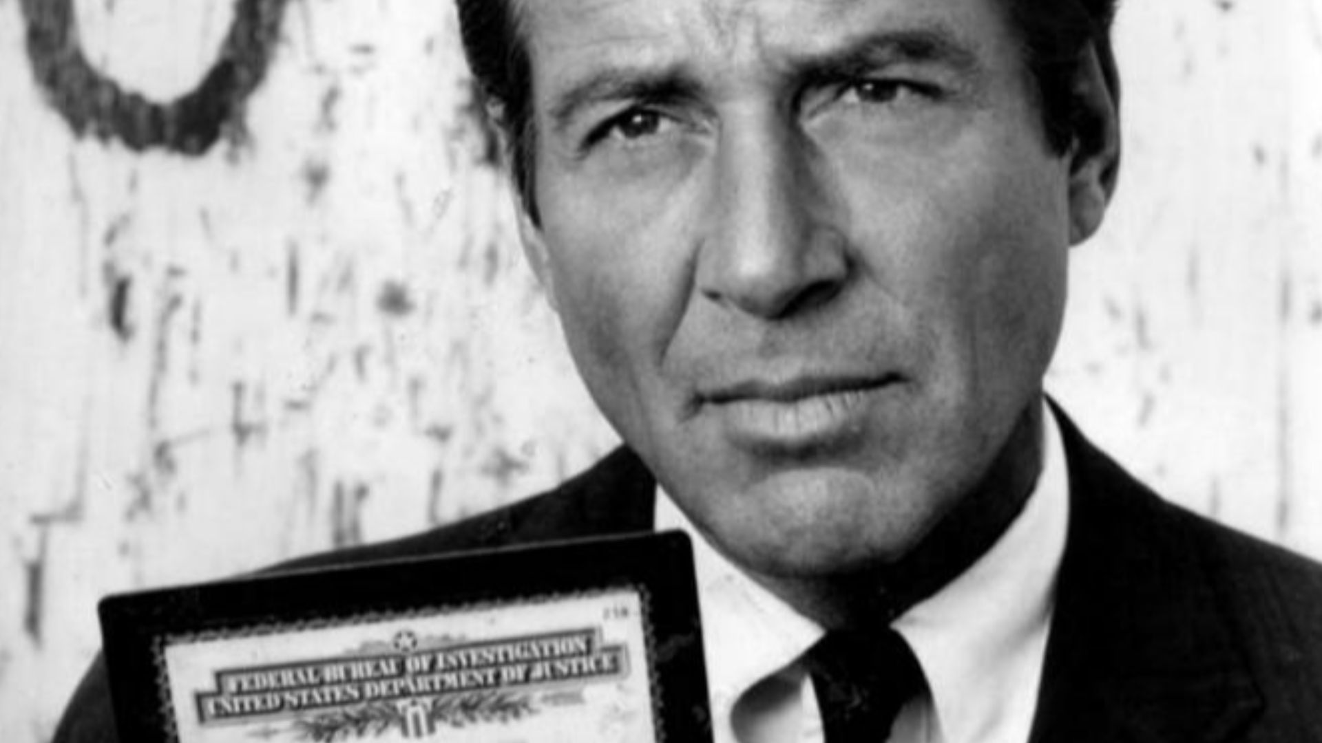 Photo of Efrem Zimbalist, Jr. as Lewis Erskine, displaying his FBI credentials from the television program The FBI.