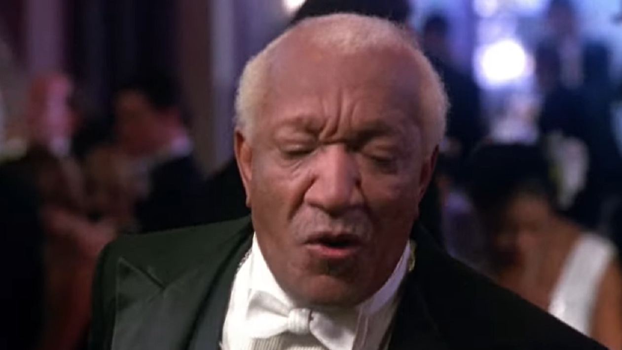 Screenshot of Redd Foxx in suit ,looking down - from Harlem Nights (1989)
