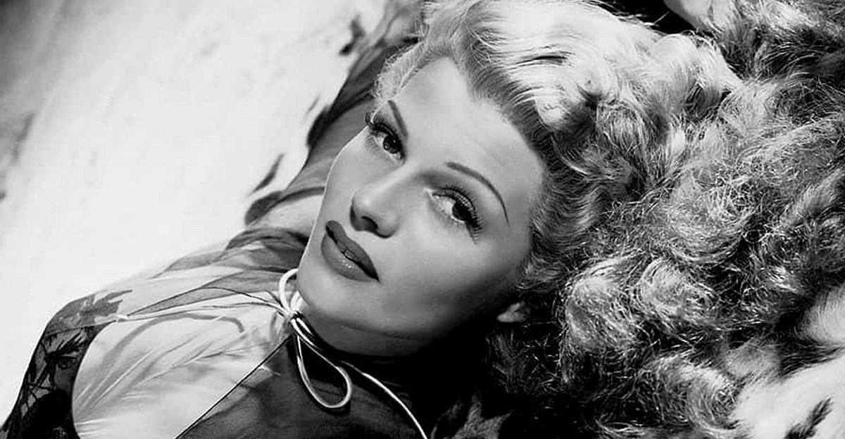 American actress Rita Hayworth (1918 -1987) reclining on an animal skin rug, circa 1942