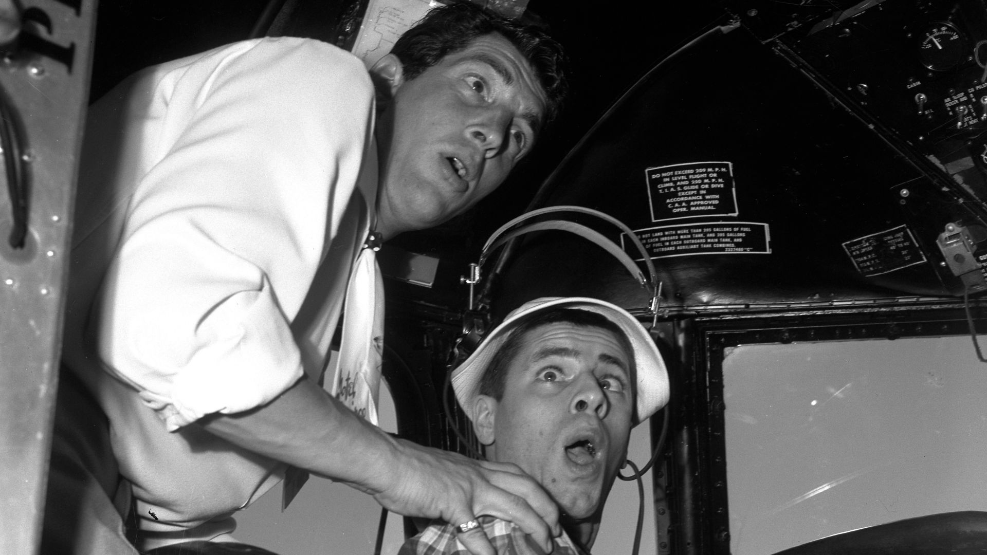 Comedians Dean Martin and Jerry Lewis mugging it up in cockpit of airplane