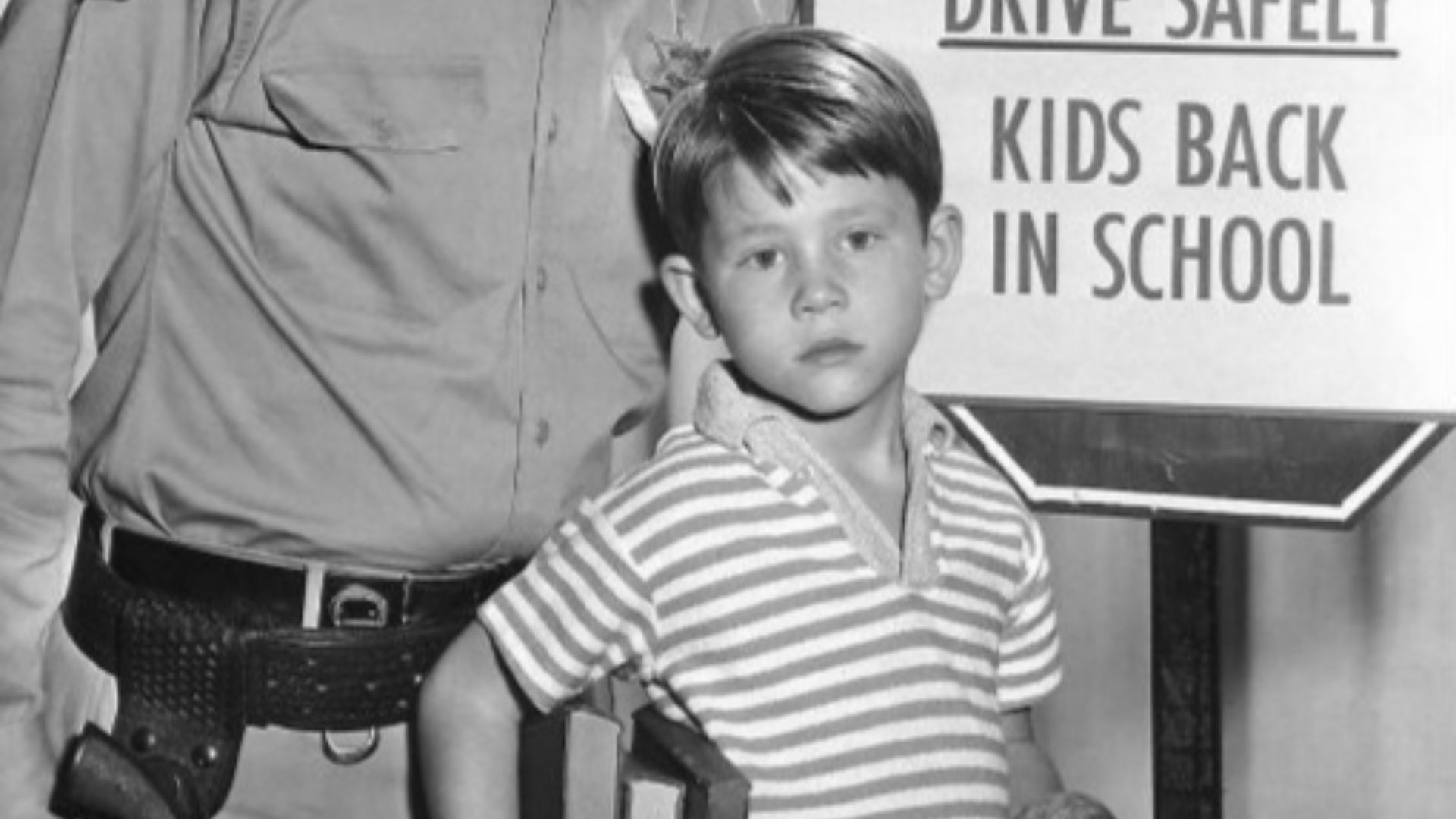 Publicity photo of Andy Griffith and Ron Howard from the television program The Andy Griffith Show.  The photo was to remind people when the show would return to the air with new episodes and to be careful driving because it was now school time.