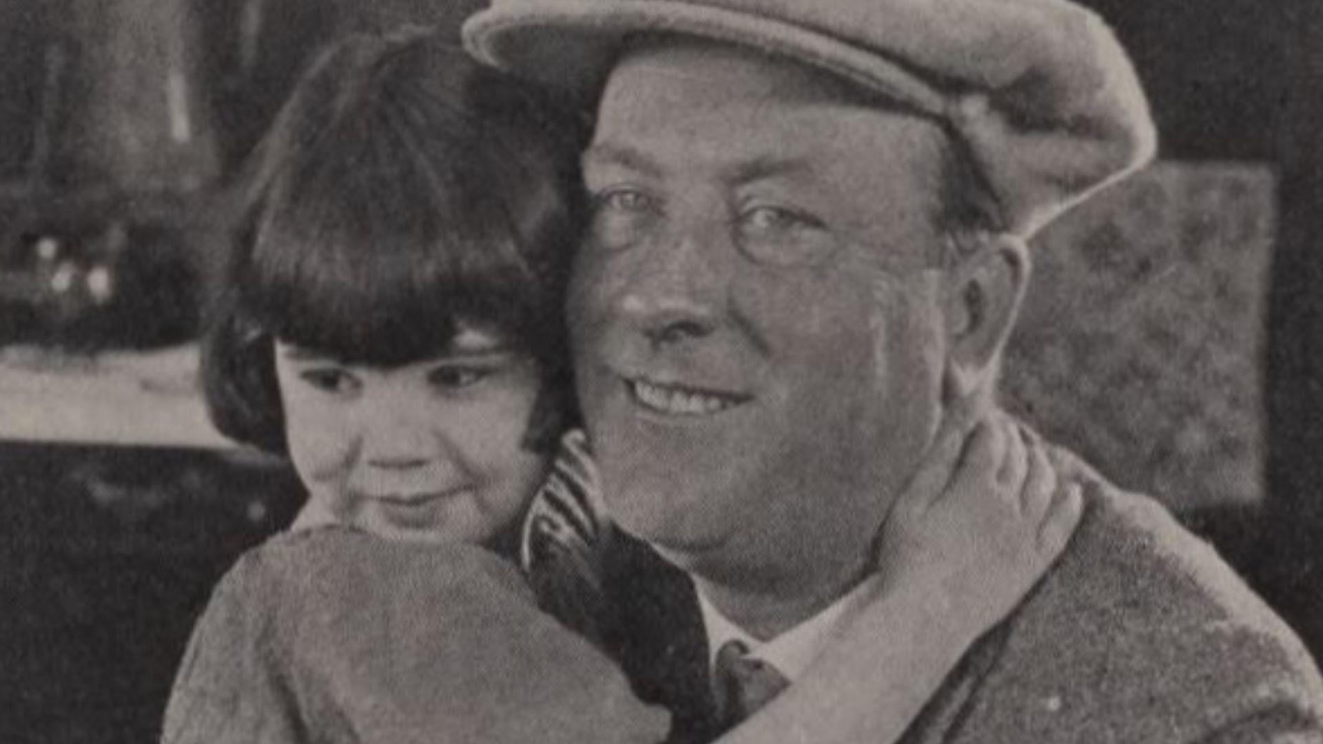 Still from the American comedy film The Darling of New York (1923), captioned under its working title Whose Baby Are You?, with Diana Serra Cary aka Baby Peggy and director King Baggot, on page 27 of the August 4, 1923 Universal Weekly.