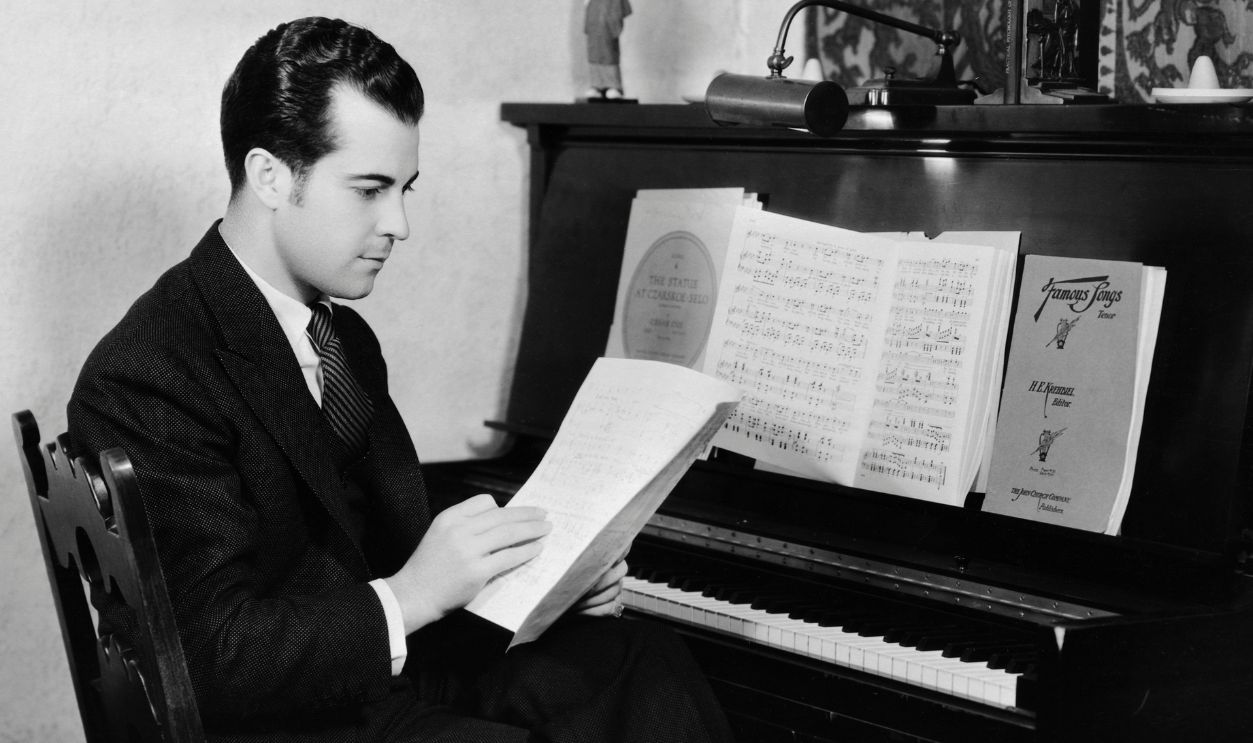Actor Ramon Novarro Reading at Piano
