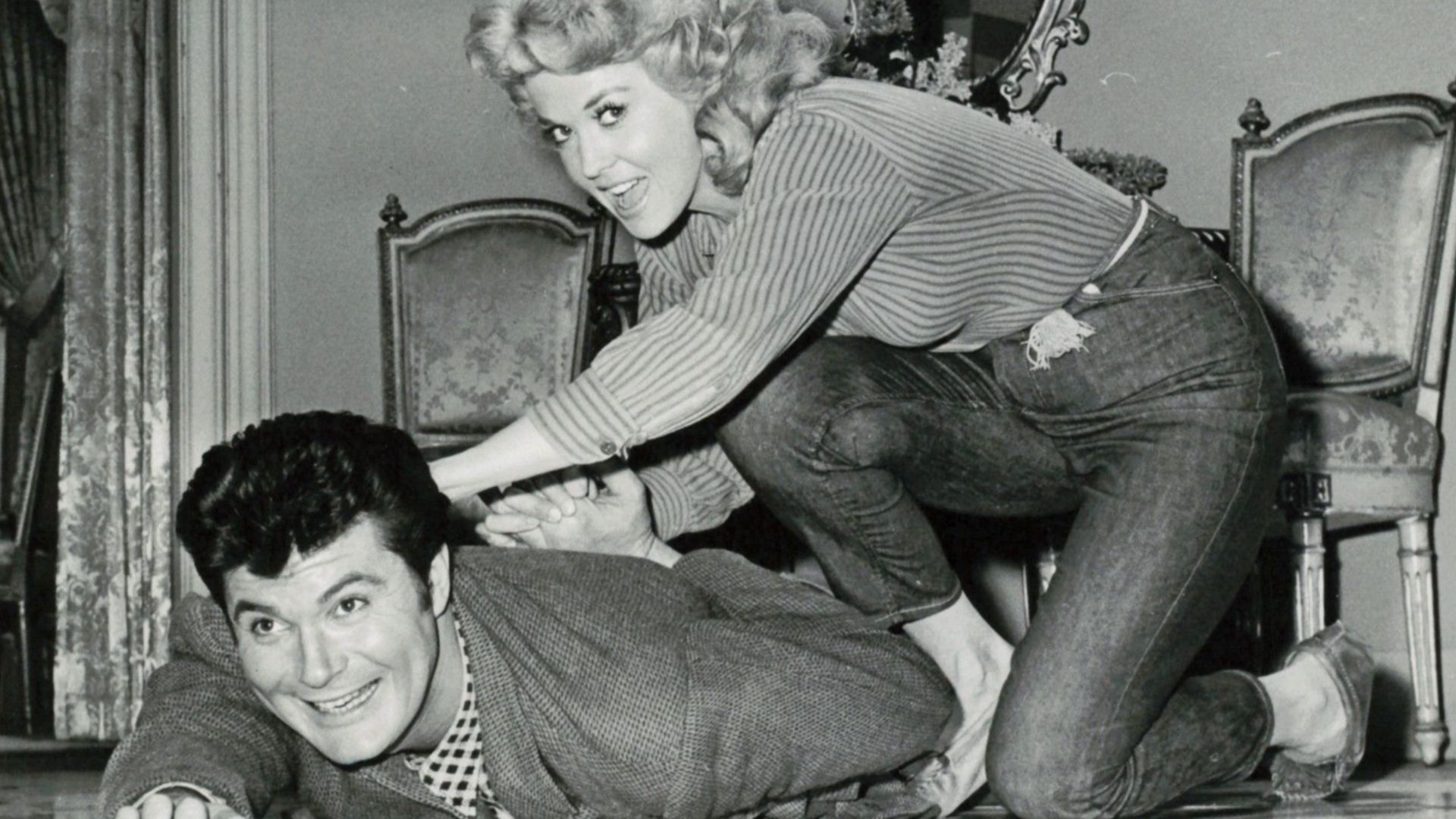 CRITICS BOO, FANS BOOST
Two of the TV hillbillies who struck oil on the show and gold in the ratings, Donna Douglas and Max Baer Jr., go through a bit of horseplay on the set in Hollywood. The quick rise of Beverly Hillbillies to the top spot in TV ratain