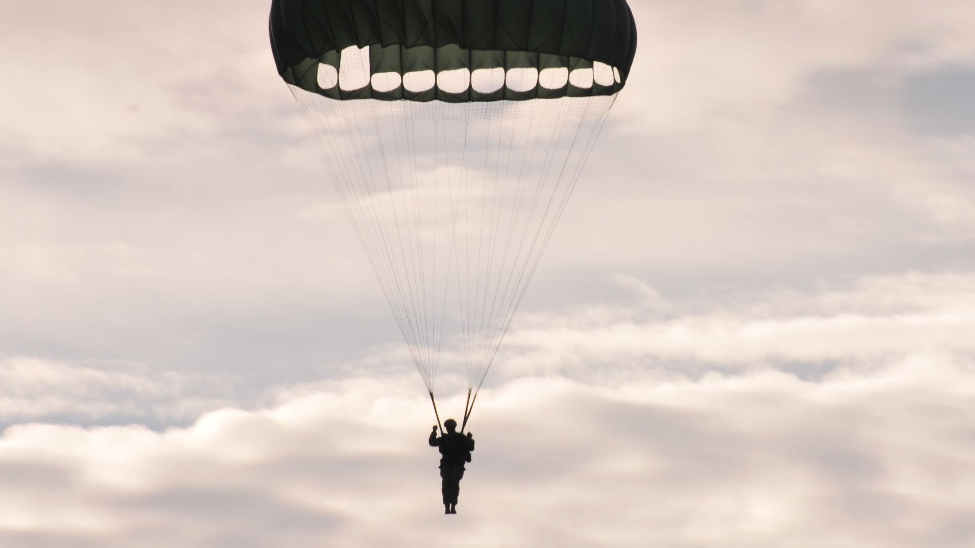 A U.S. Army paratrooper descends on Luzon Drop Zone after exiting an aircraft for the 17th Annual Randy Oler Memorial Operation Toy Drop, hosted by U.S. Army Civil Affairs and Psychological Operations Command (Airborne), Dec. 11, 2014, at Camp Mackall, N.