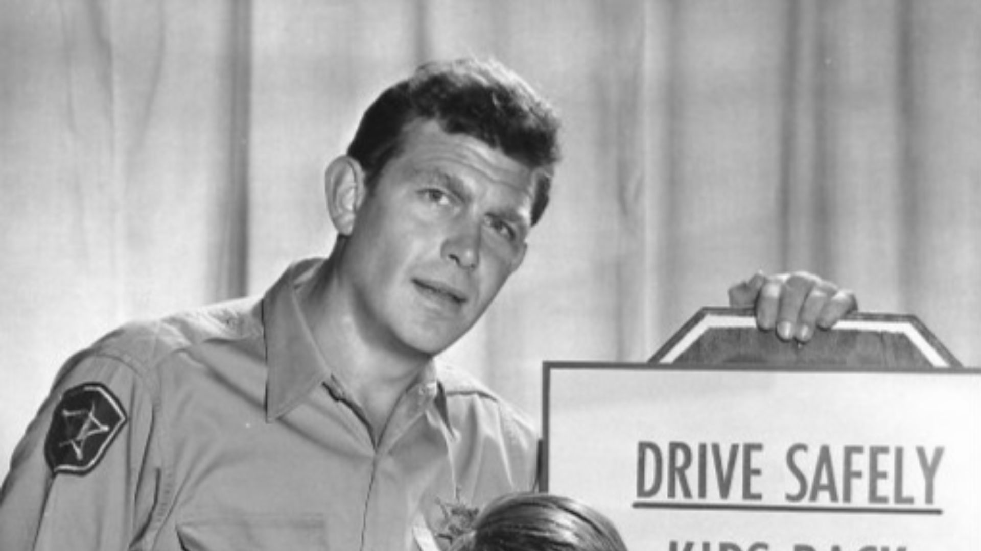 Publicity photo of Andy Griffith and Ron Howard from the television program The Andy Griffith Show.  The photo was to remind people when the show would return to the air with new episodes and to be careful driving because it was now school time.