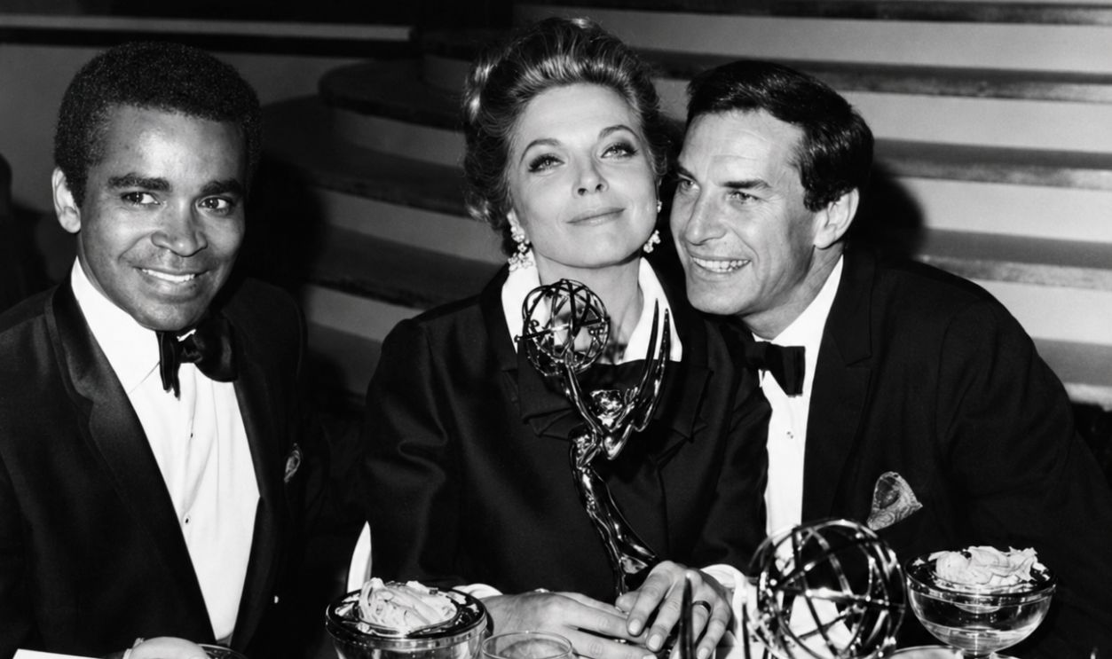 Actors Greg Morris (left) and Martin Landau sitting with actress Barbara Bain as she holds on to her award for the show 'Mission: Impossible', at the Emmy Awards, circa 1968.