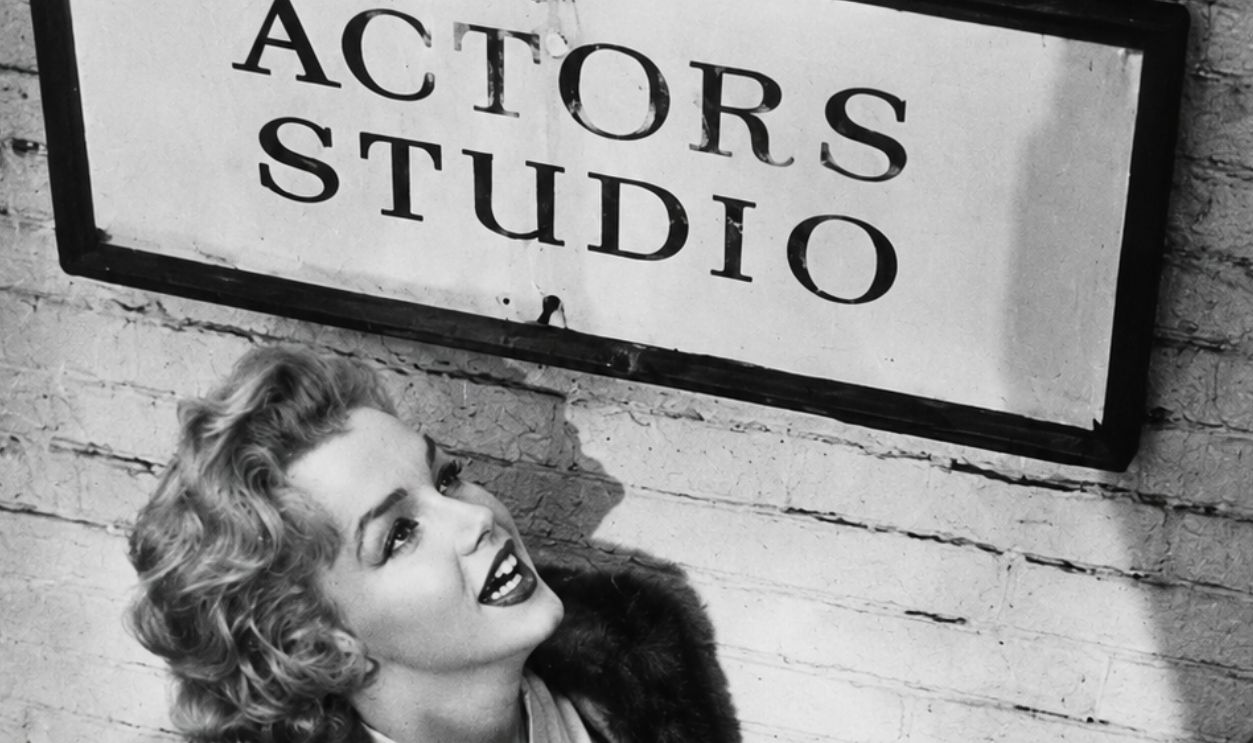Photo of Marilyn Monroe posing below an Actors Studio sign from the May 1955 issue of TV-Radio Mirror