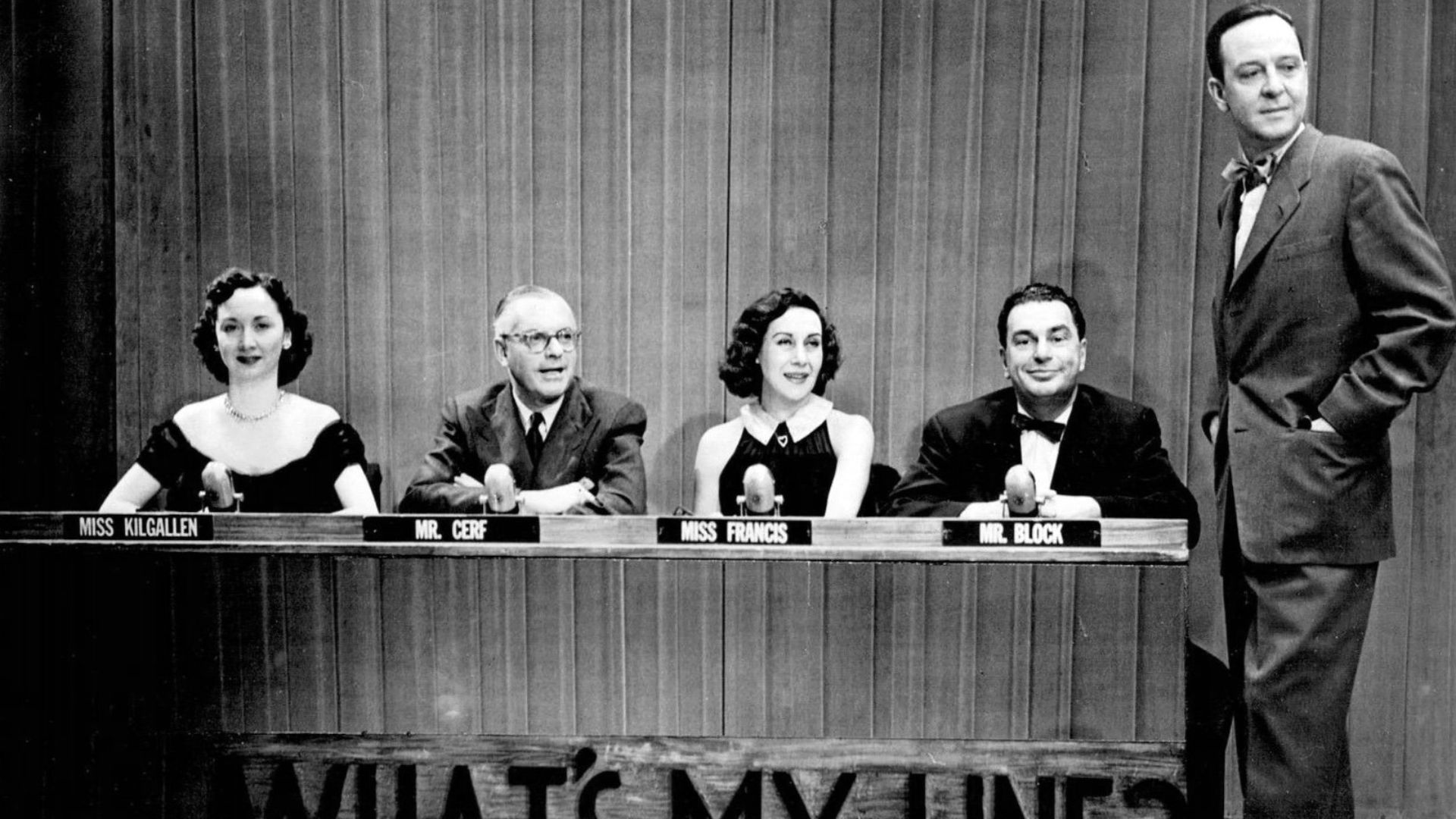 Photo of the original What's My Line? television set and panel of the show.  From left: Dorothy Kilgallen, Bennett Cerf, Arlene Francis, Hal Block and host John Daly.
