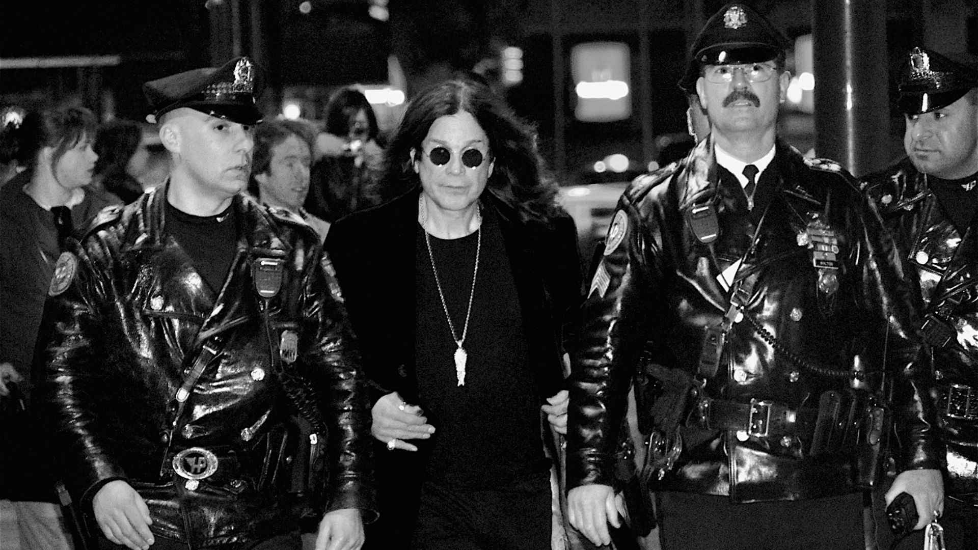 Ozzy Osbourne, flanked by Philadelphia police officers, leaves Borders in Center City after signing copies of his new autobiography,
