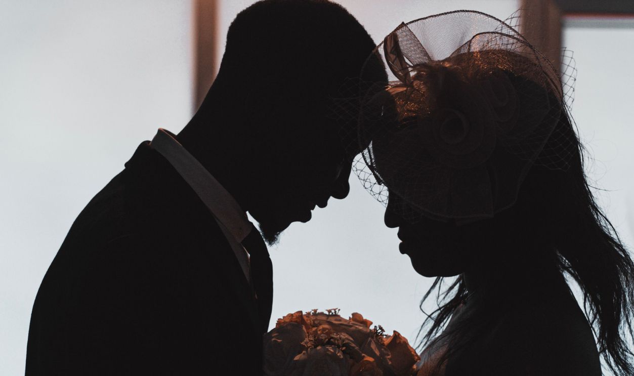 Silhouette of a couple sharing a tender moment indoors, emphasizing romance and intimacy.