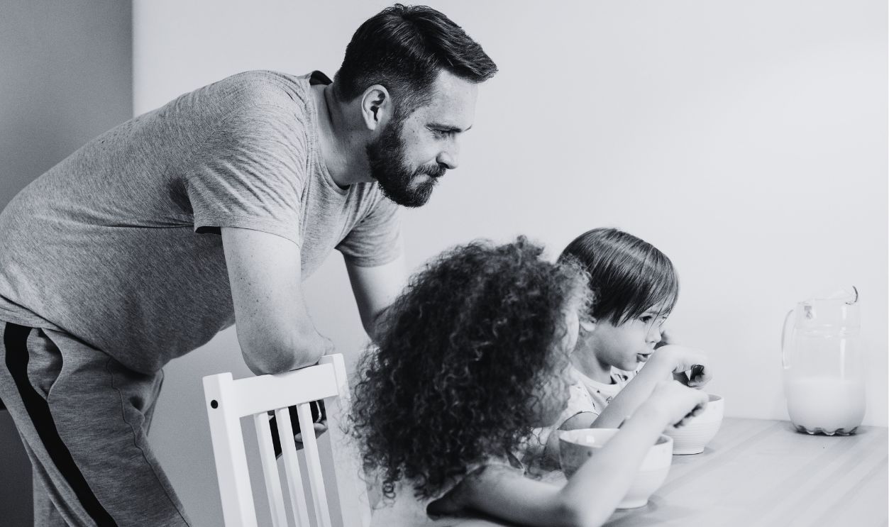 A father and children enjoying breakfast together indoors, creating a warm family bond
