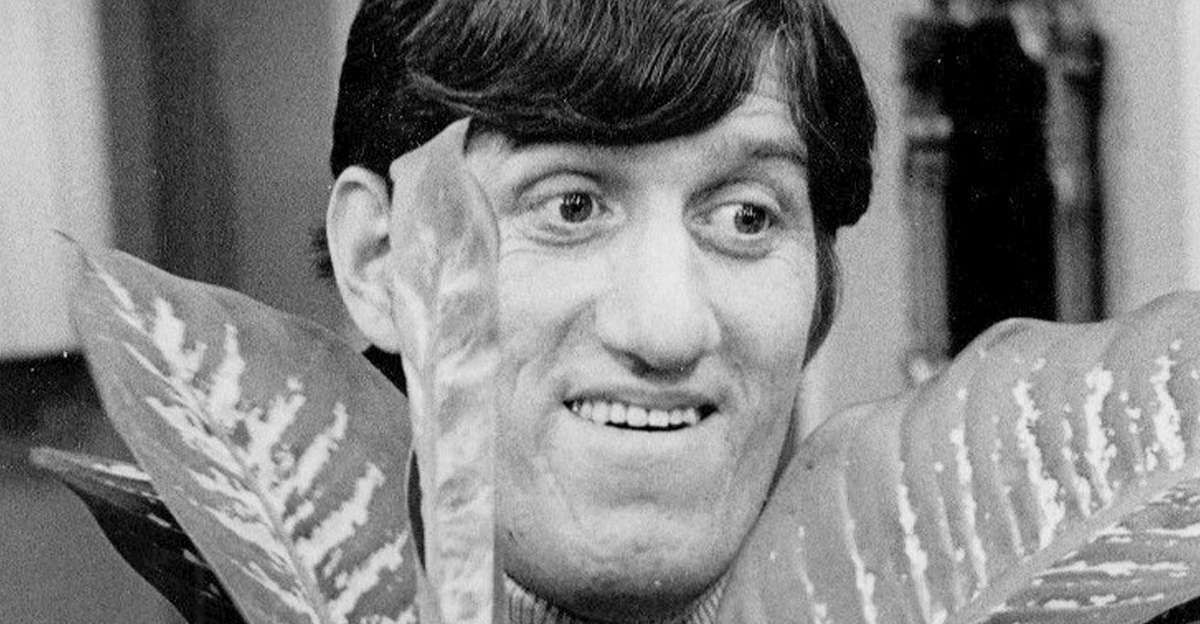 Photo of Paul Benedict with a plant.