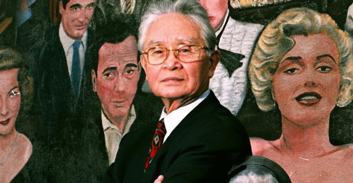 Dr. Thomas Noguchi photographed besides a mural of Hollywood stars who are dead, off Hollywood Boulevard
