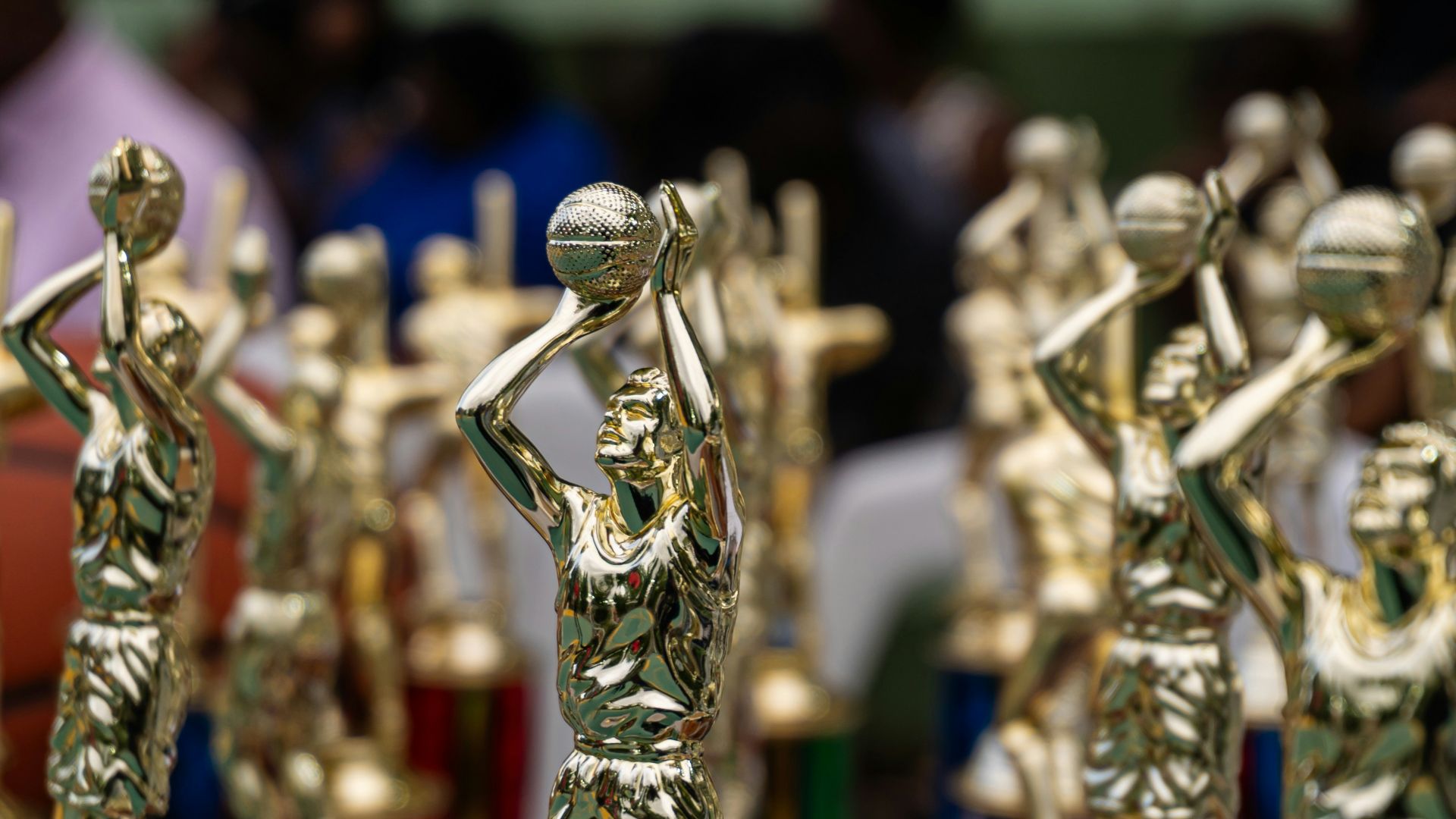 Rows of golden trophies displayed at an event