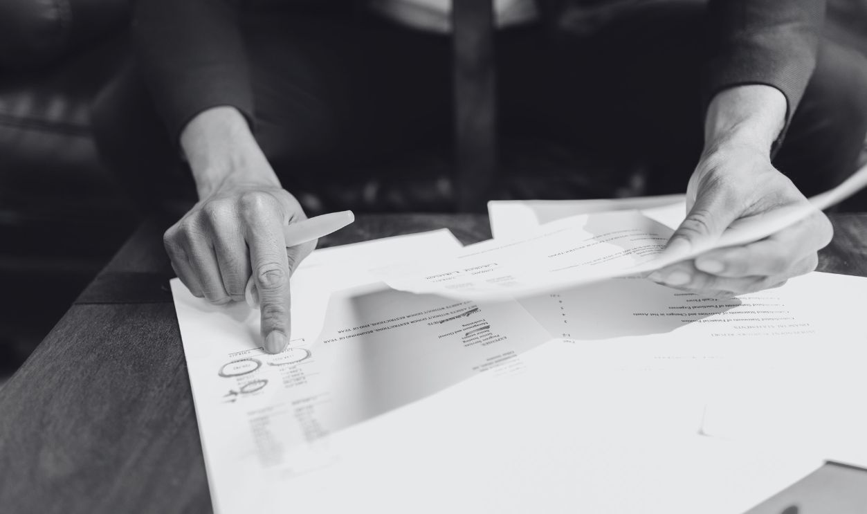 A businessman analyzing financial documents with important data and figures on a desk, ideal for business analytics and accounting themes.