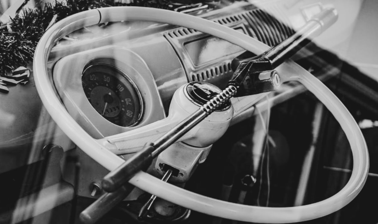 Close-up of a classic car's steering wheel with an anti-theft lock