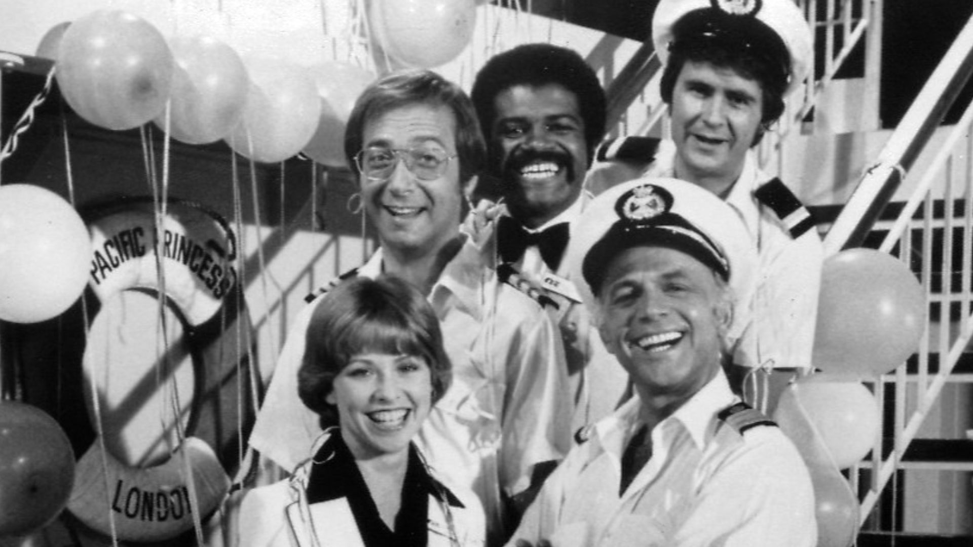 Publicity photo of cast for The Love Boat series premiere. Shown are Julie (Lauren Tewes), Captain Stubing (Gavin MacLeod), Doctor Bricker (Bernie Kopell), Isaac (Ted Lange), and Gopher (Fred Grandy).
This photo was produced prior to 1978 and has no copyr