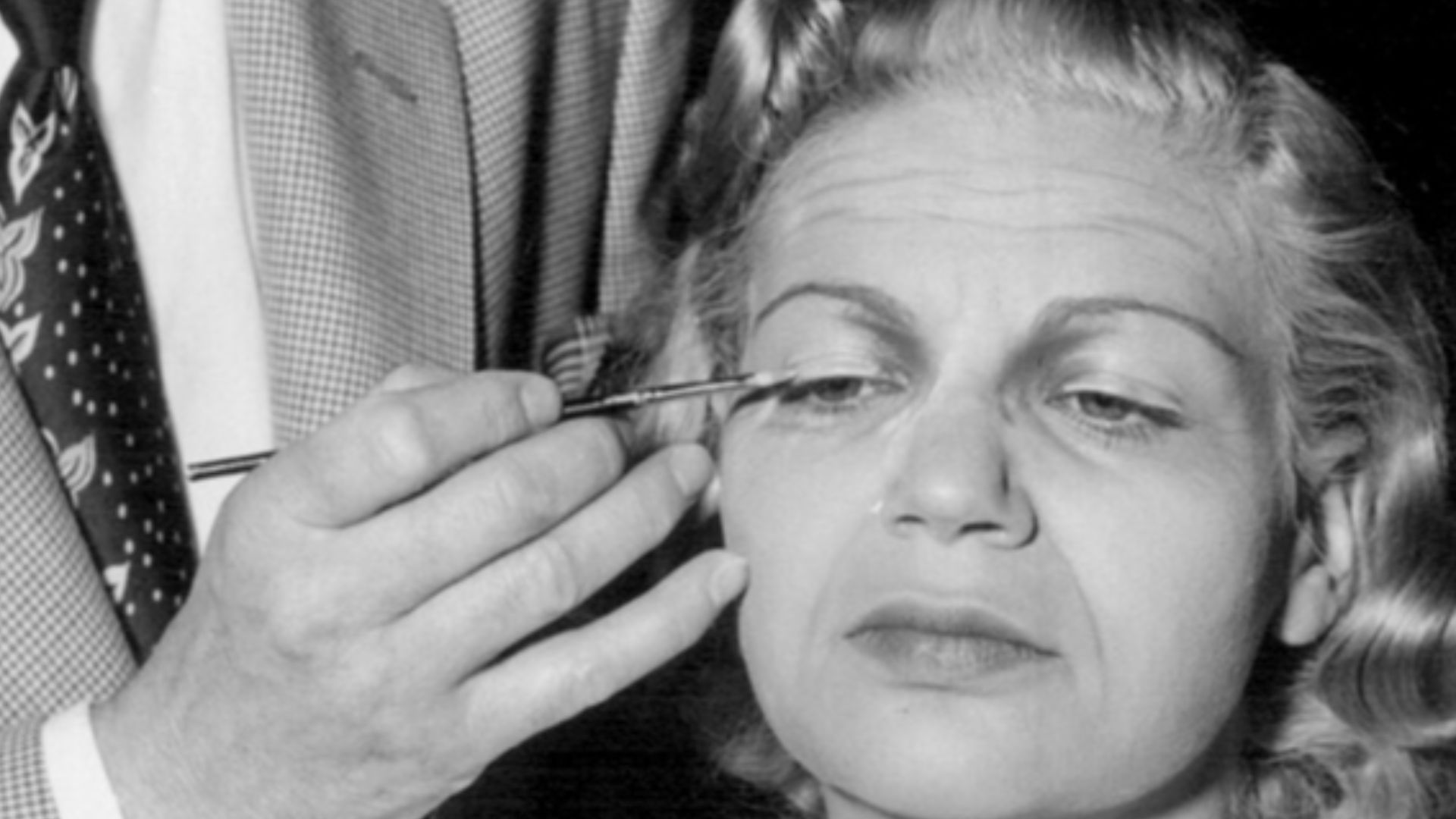 Photo of makeup artist John Sweeney applying makeup to actress Florence Halop for her role as