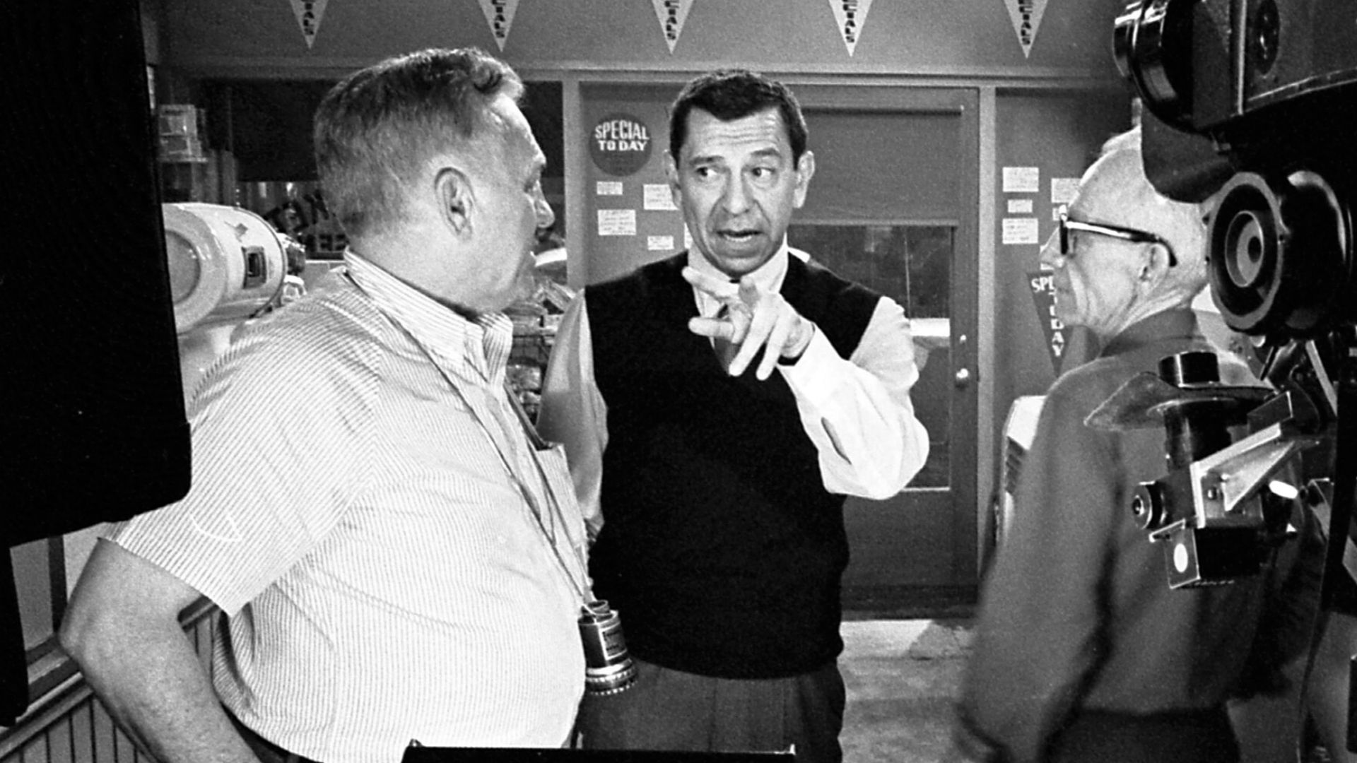 Jack Webb, center, confers with cinematographer Walter Strenge, left, and crewman Ray Bensfield on set of Dragnet 1966.