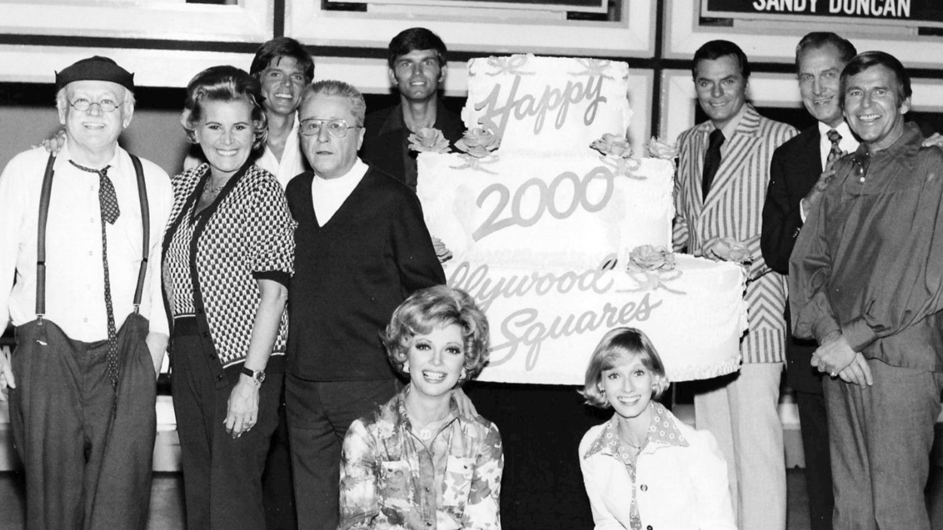 Photo from the television game show Hollywood Squares.  This was to celebrate the 2,000th show in 1974.  Pictured are Cliff Arquette as Charley Weaver, Rose Marie, John Davidson, George Gobel, Kent McCord, Peter Marshall, Vincent Price, Paul Lynde, Sandy 