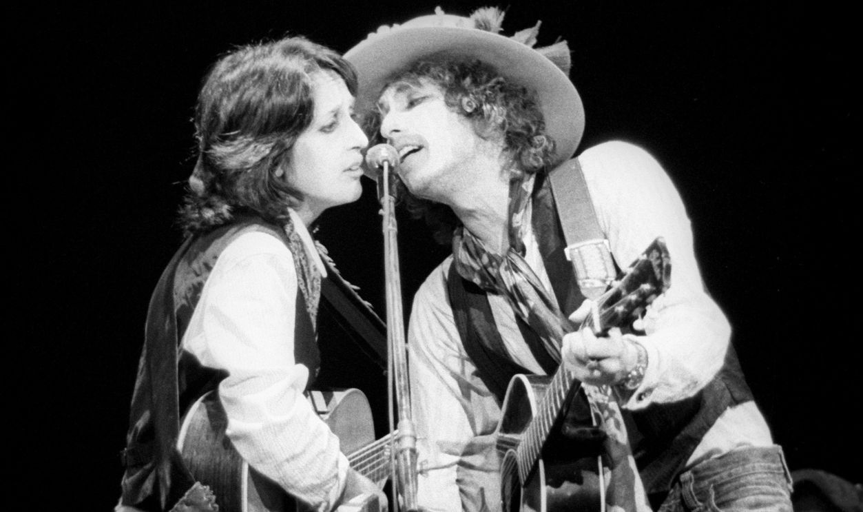 NEW YORK CITY - DECEMBER 8: American singer-songwriter, musician and activist, Joan Baez, and American singer-songwriter, multi-instrumentalist and author, Bob Dylan, perform in Madison Square Garden during his Rolling Thunder Revue's "Night of the Hurricane," a benefit concert for boxer Rubin Carter, on December 8, 1975, in New York, NY.