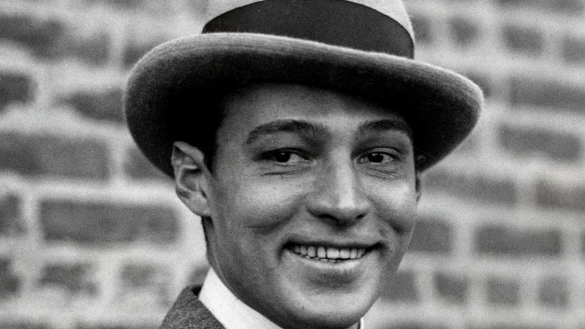 Omschrijving: Filmster Rudolf Valentino rookt een sigaret, Verenigde Staten jaren '20.