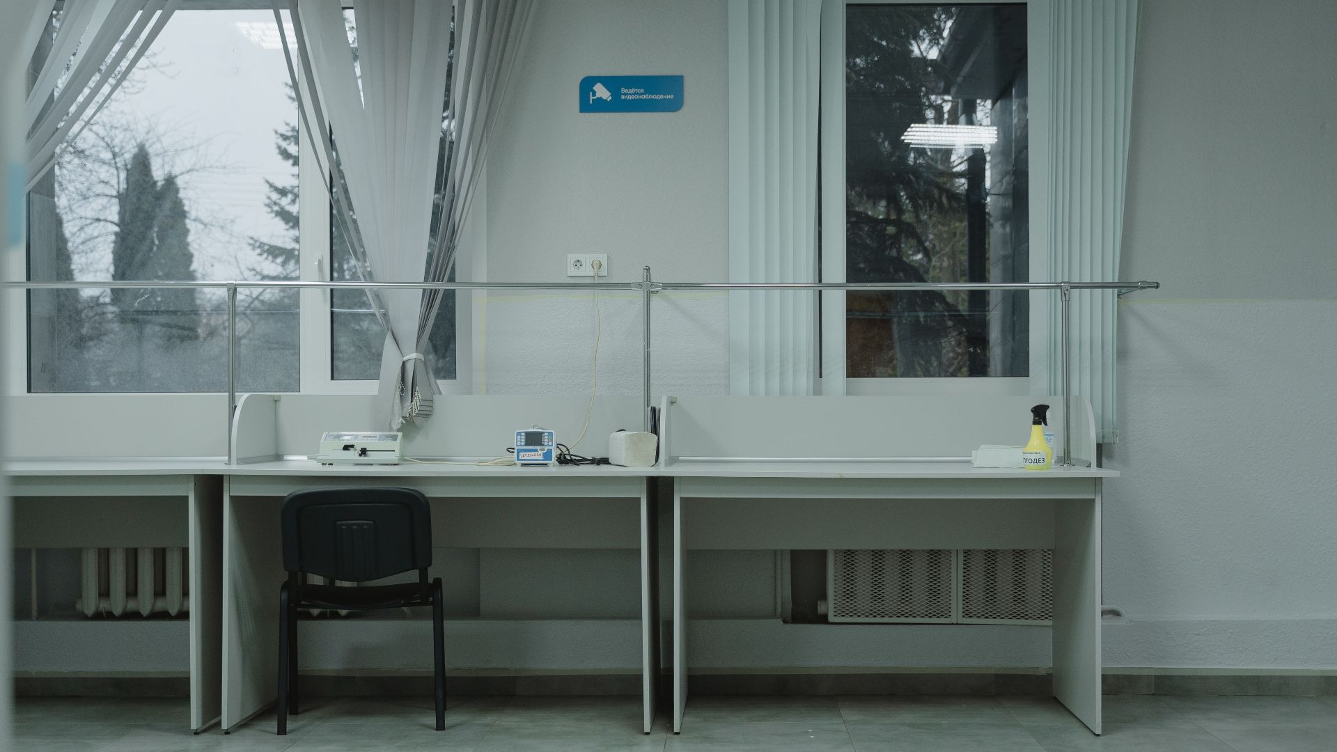 A clean and organized office space with desks, chairs, and large windows providing natural light.