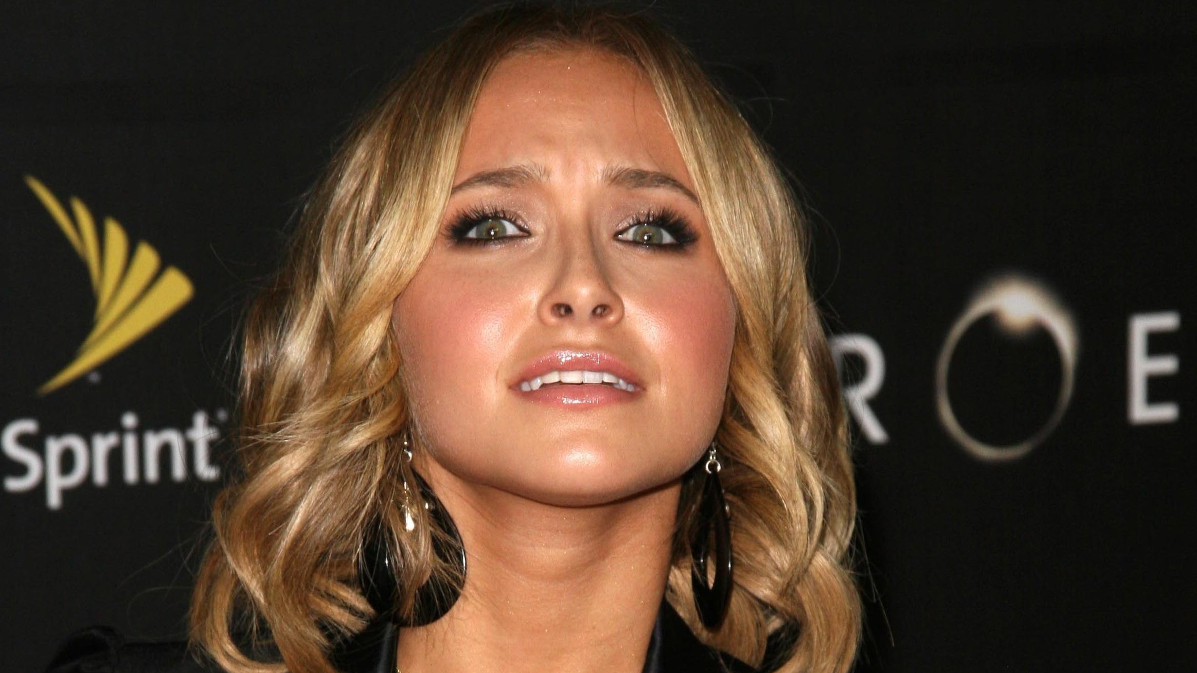 Hayden Panettiere with blonde hair wearing black suit and earings looking at front scared - 2008