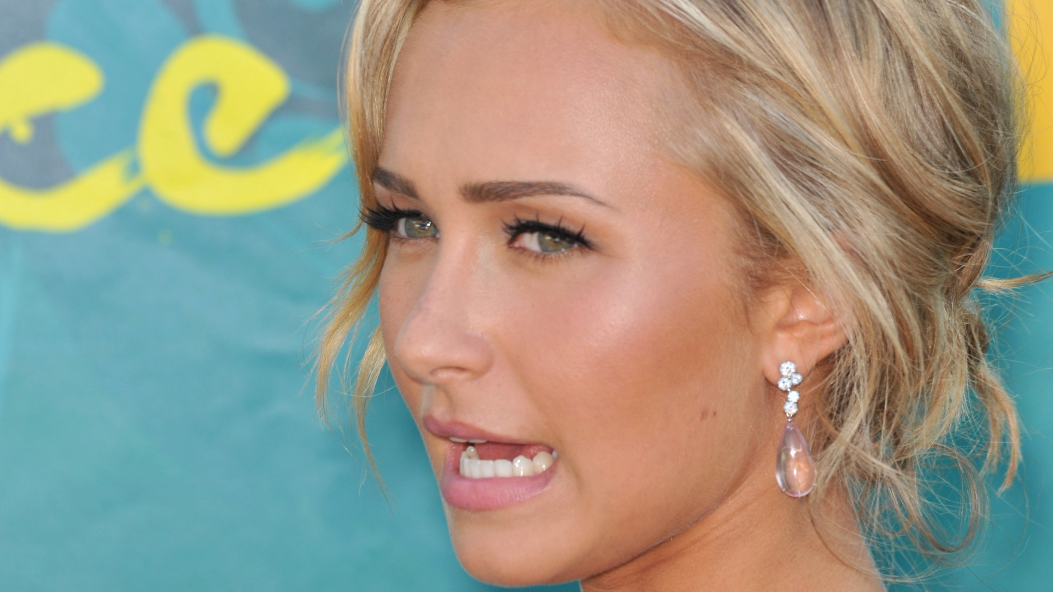 Hayden Panettiere wearing pink dress and transparent earrings with open mouth, looking at side on the blue background - 2009